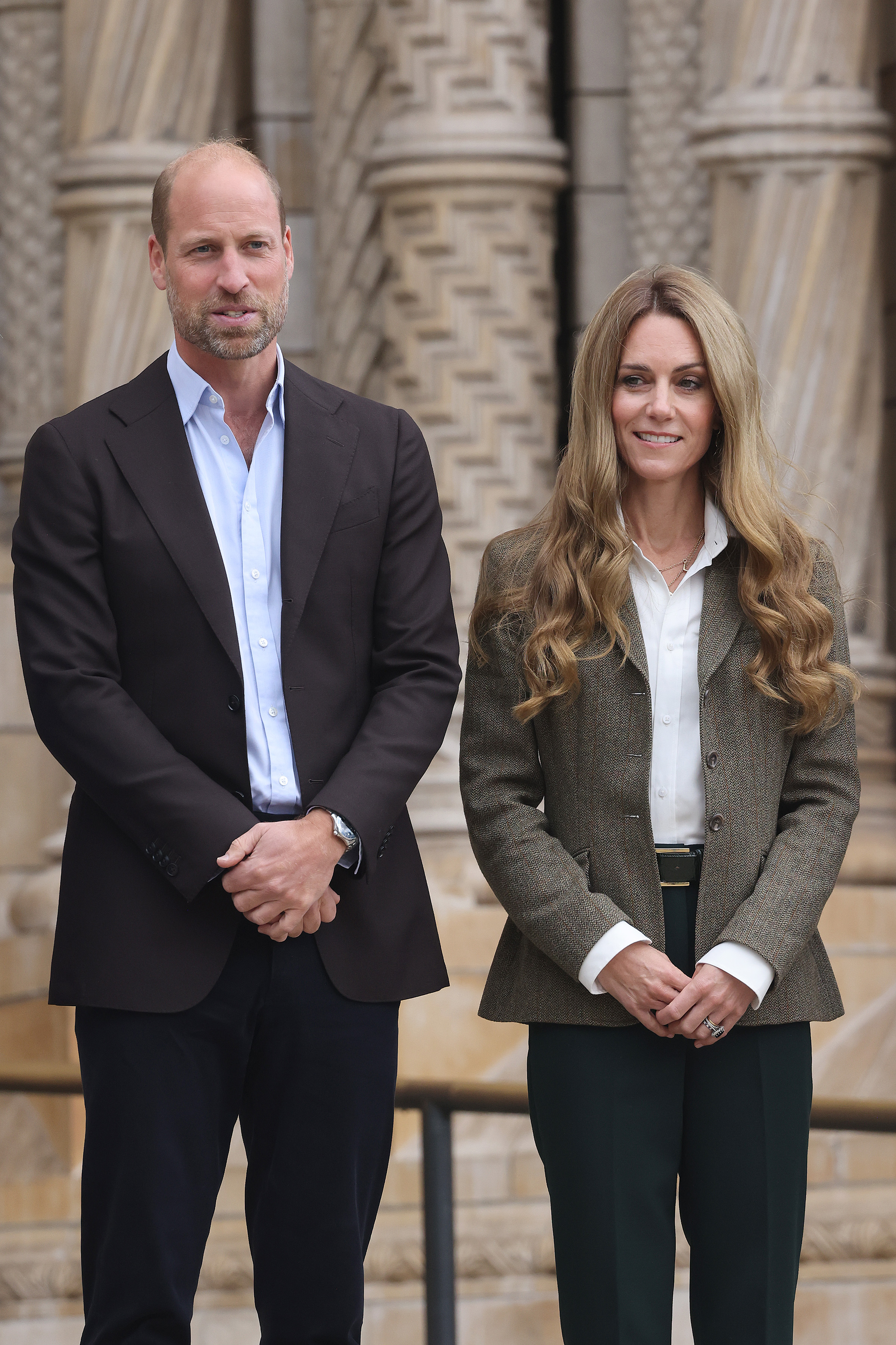 During the royal couple's outing to the Natural History Museum, Princess Catherine poses alongside Prince William. Her wavy, light hair stands out against the textured stone backdrop of the venue's historic architecture.