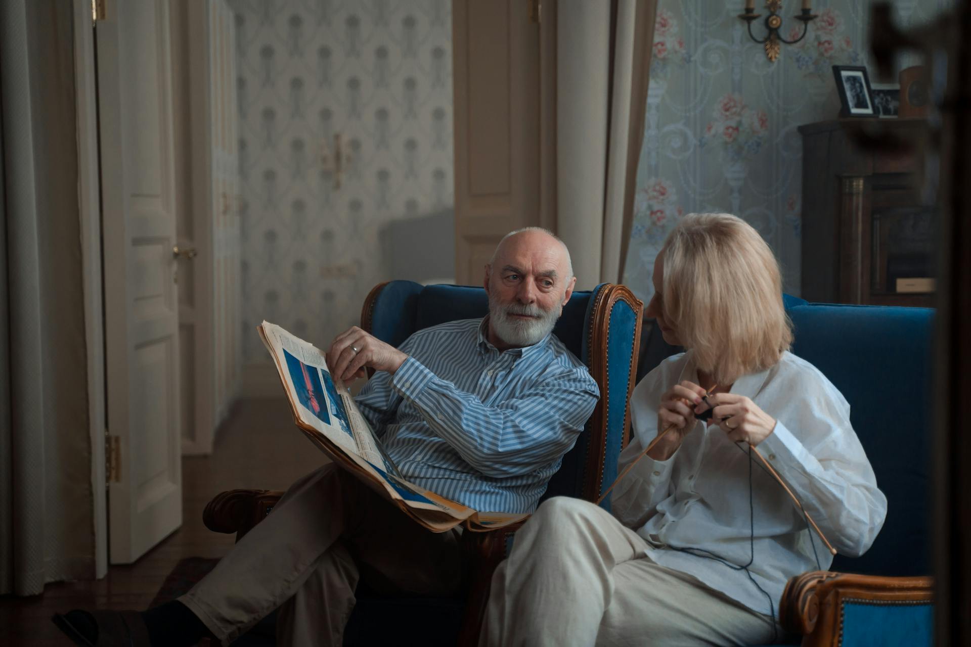 An elderly couple sitting and reading a newspaper | Source: Pexels