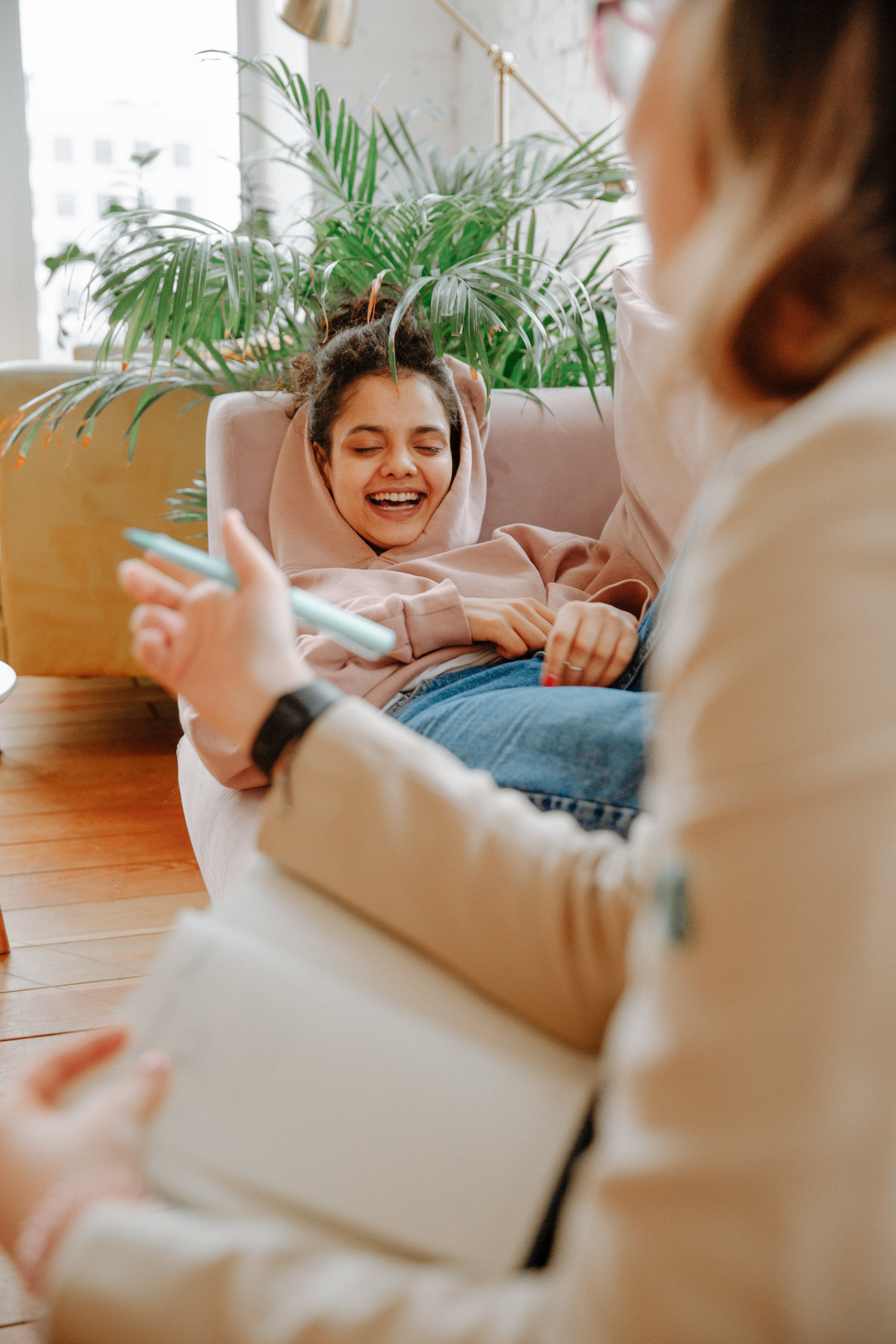 A woman laughing on the couch. | Source: Pexels