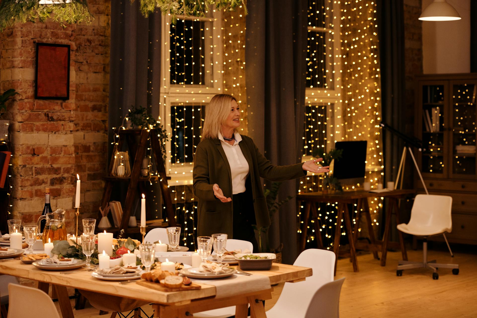 A woman standing and waiting near a dining table to welcome guests | Source: Pexels