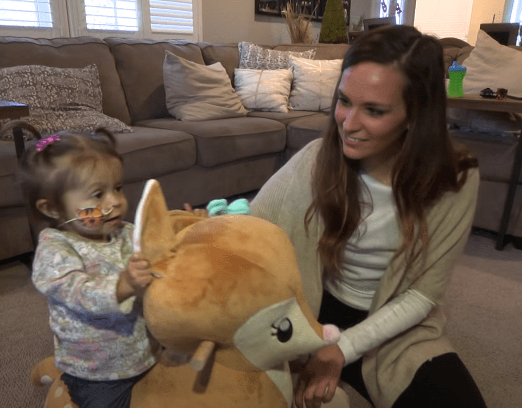A young child plays with her nanny who donated part of her liver to save her | Photo: Youtube/PIX11 News