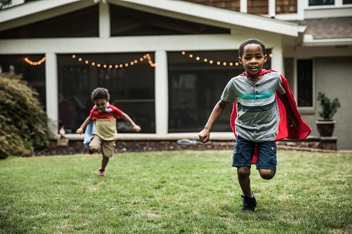 Photo of young boys in capes playing in backyard | Photo: Getty Images
