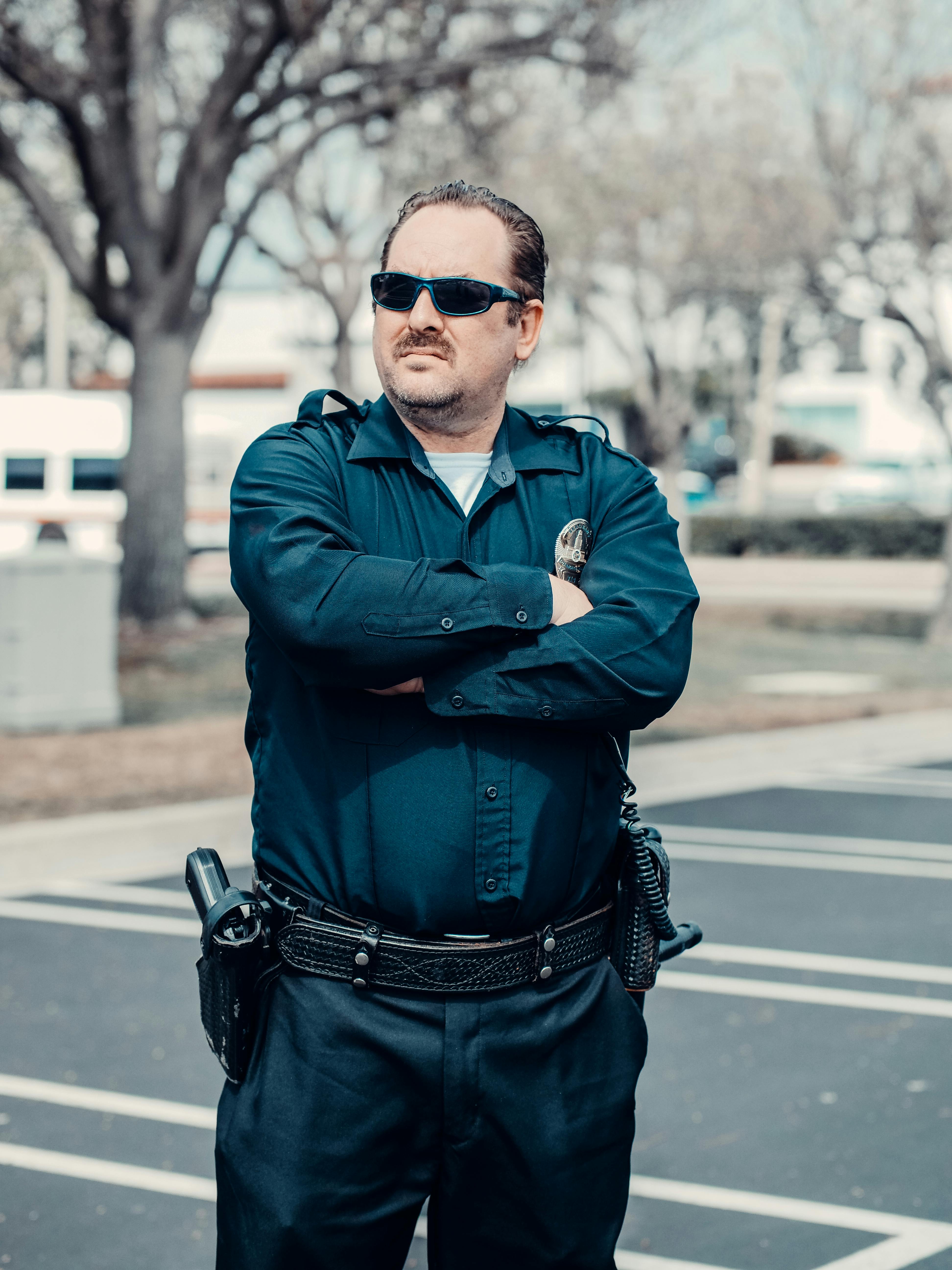 An annoyed policeman with his hands folded against his chest | Source: Pexels