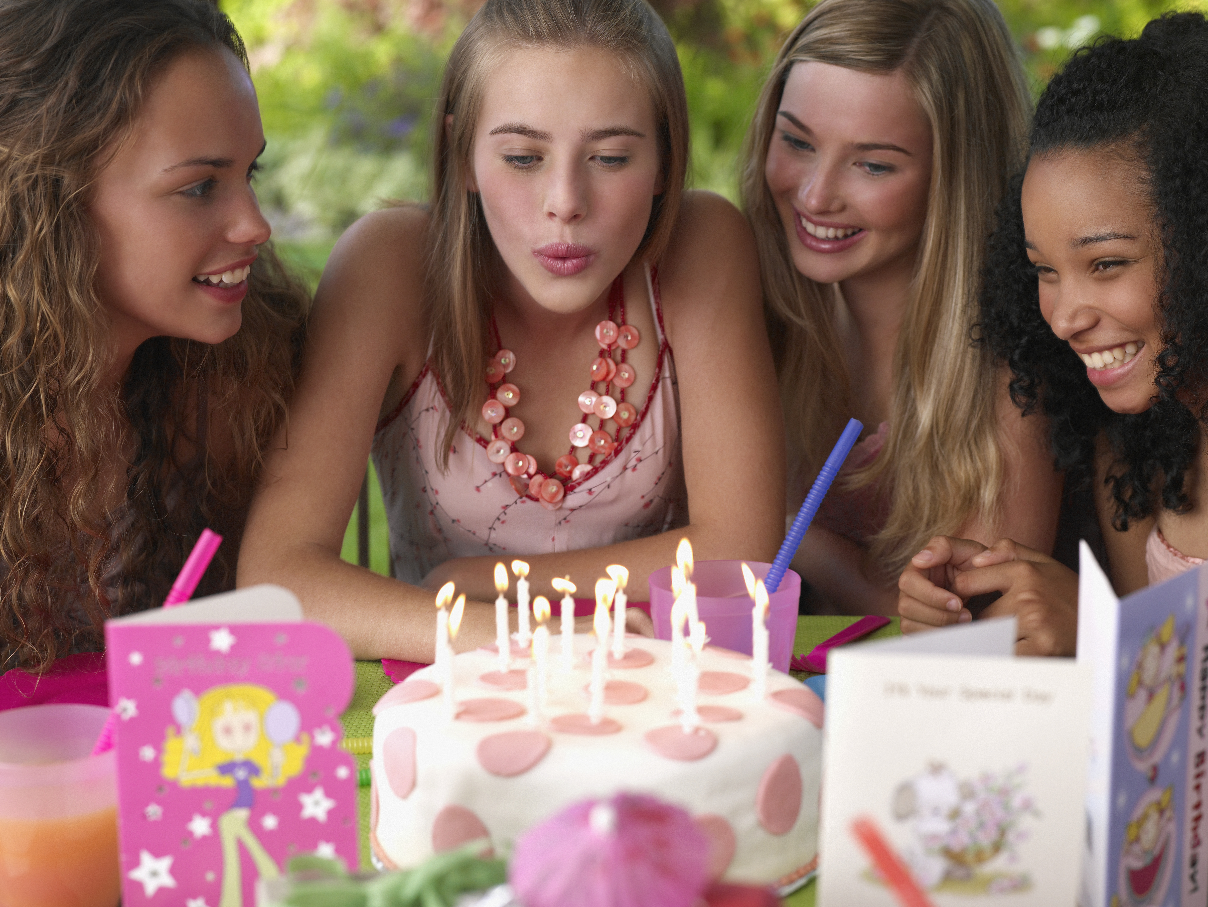 Four teenage girls at birthday party smiling outdoors | Source: Getty Images