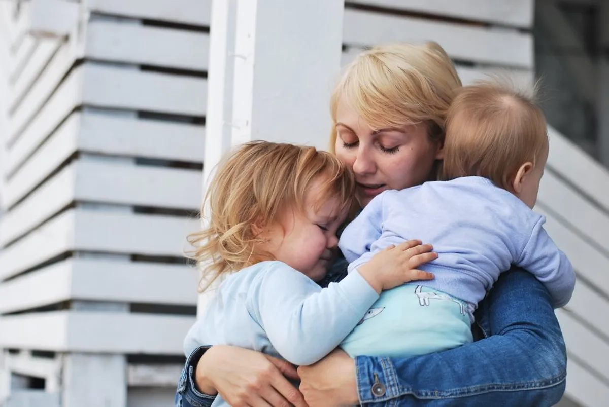 Mujer triste con sus dos hijos. | Foto: Shutterstock