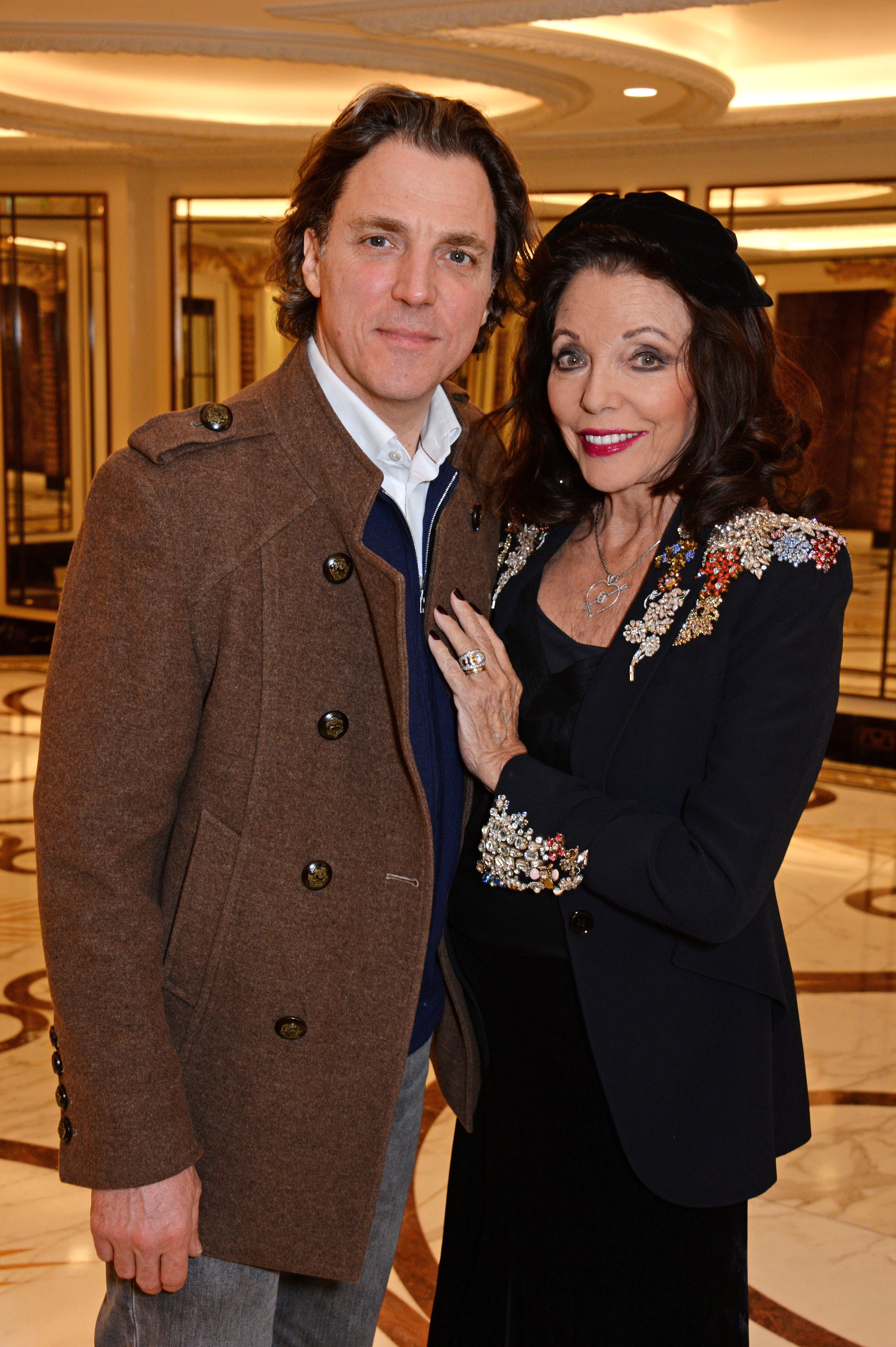 Alexander Newley and Dame Joan Collins attend a festive afternoon tea hosted by patron Dame Joan Collins for Shooting Star Chase supported children and their families at The Dorchester on December 19, 2018 in London, England | Source: Getty Images
