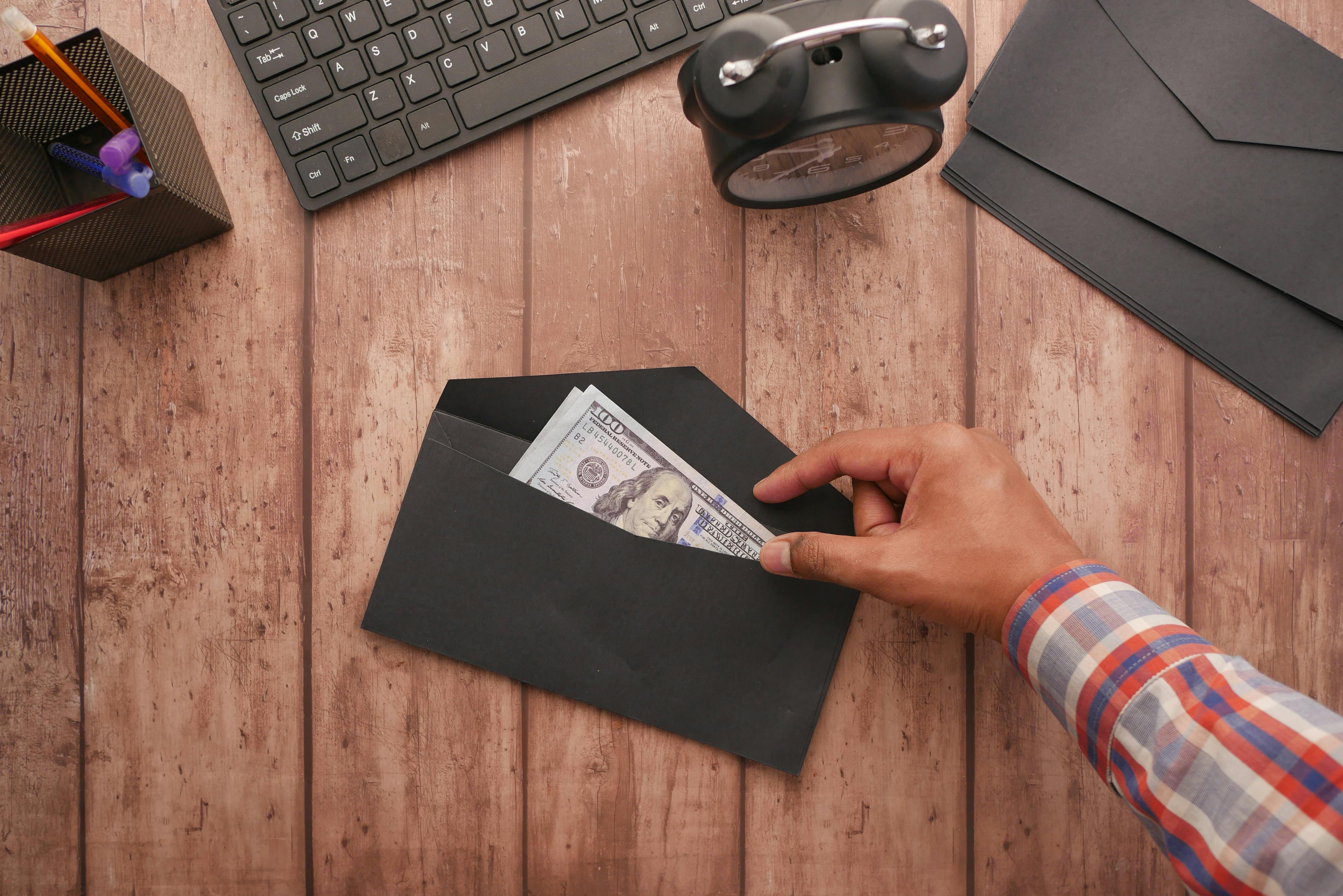 Man checking the money in the envelope | Source: Pexels