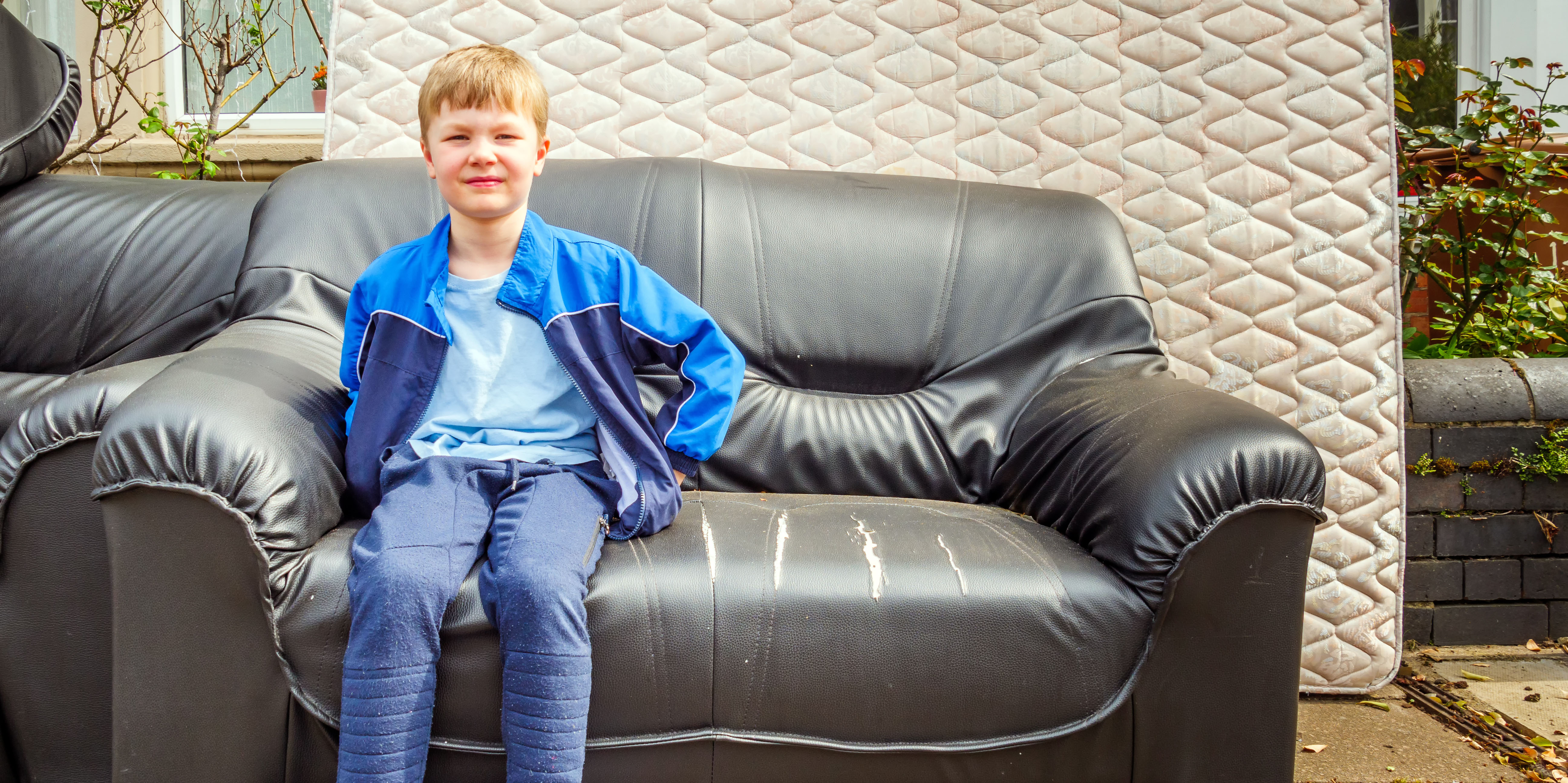 Boy sitting on a sofa | Source: Shutterstock