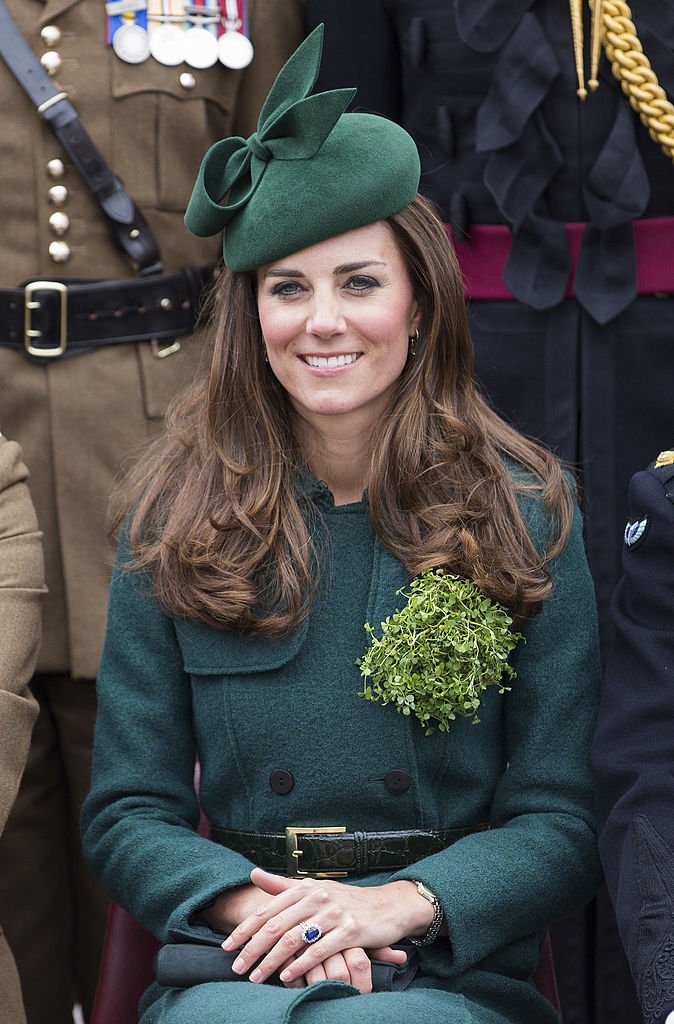 Kate Middleton, Duchess of Cambridge is all smiles while sitting down wearing an all-green ensemble with a matching headpiece | Photo: Getty Images