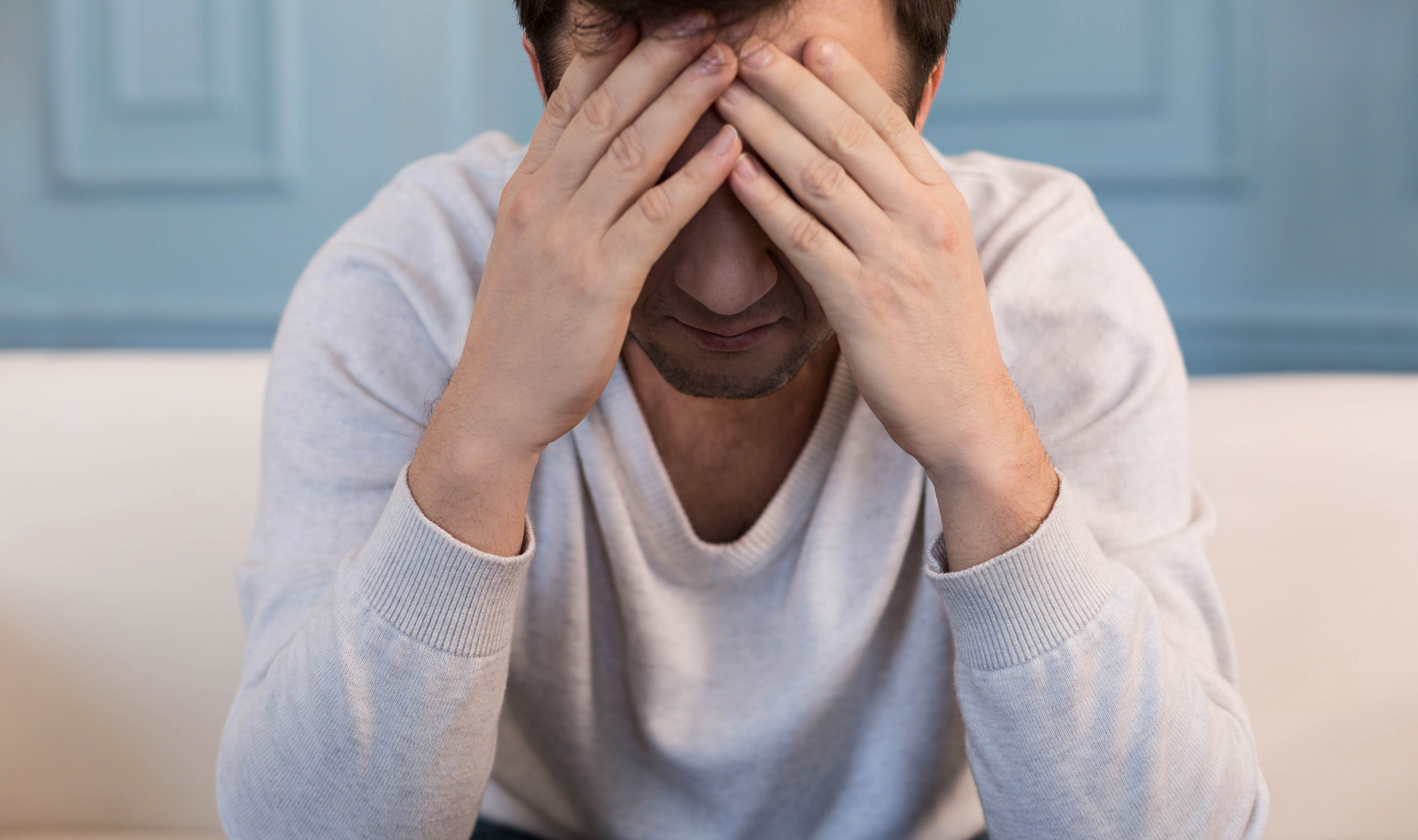 Sad cheerless man covering his face. | Source: Shutterstock