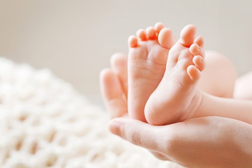 Bild einer Mutter, die die Füße ihres Babys hält | Quelle: Shutterstock