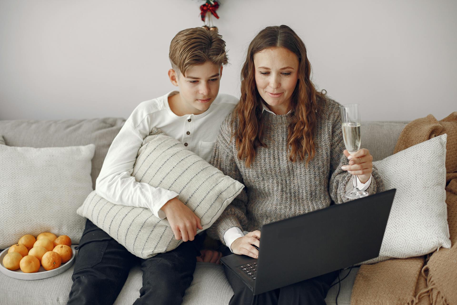 A mother-son duo sitting on a couch and using a laptop | Source: Pexels