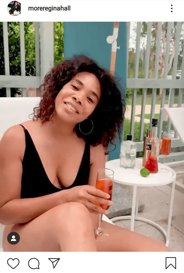 A picture of Regina Hall wearing a swimsuit and sitting on a pool bench holding a glass of wine. | Photo: Instagram/Morereginahall