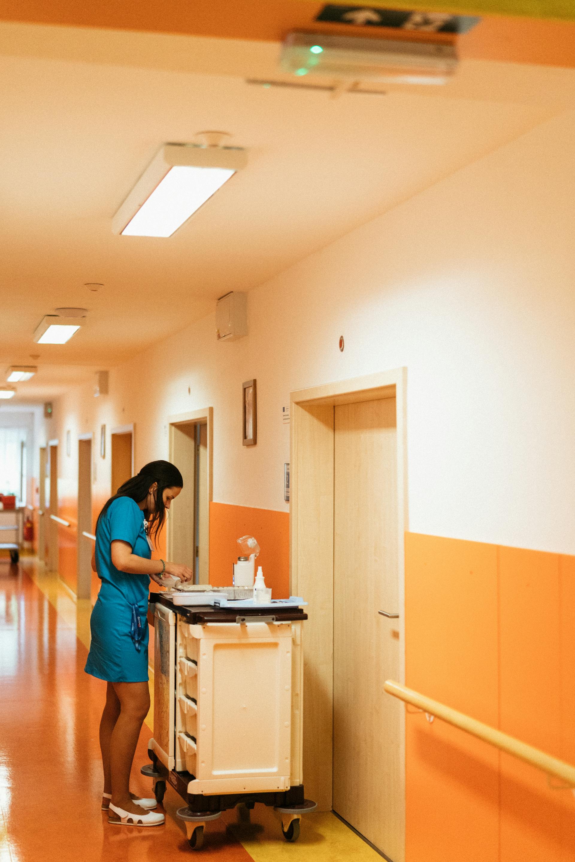 A nurse with a cart in a hospital corridor | Source: Pexels