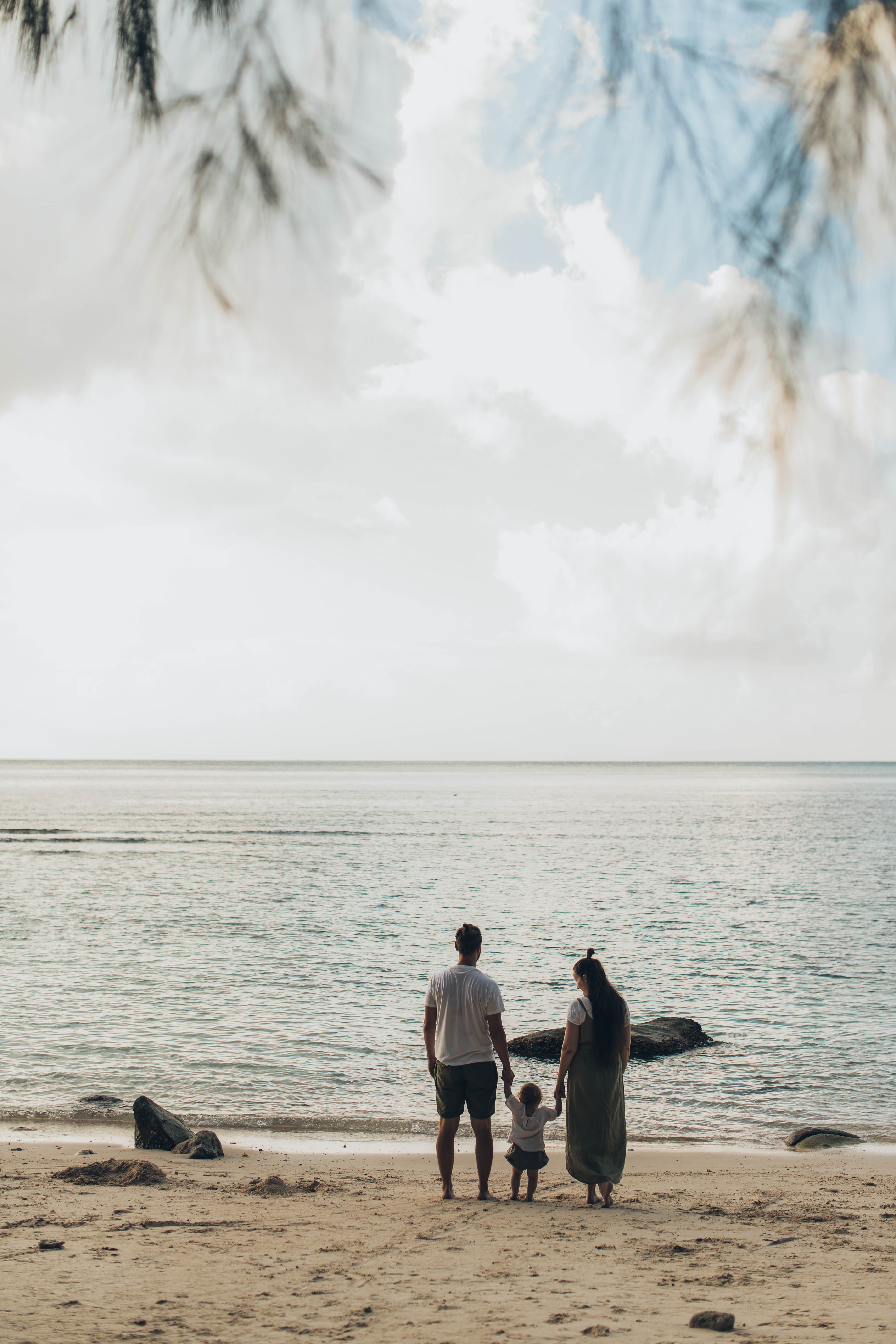 Una pareja con un bebé en la orilla de una playa. | Foto: Pexels