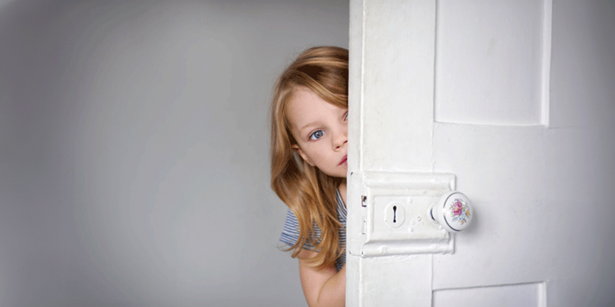 Girl is looking behind the door | Source: Shutterstock