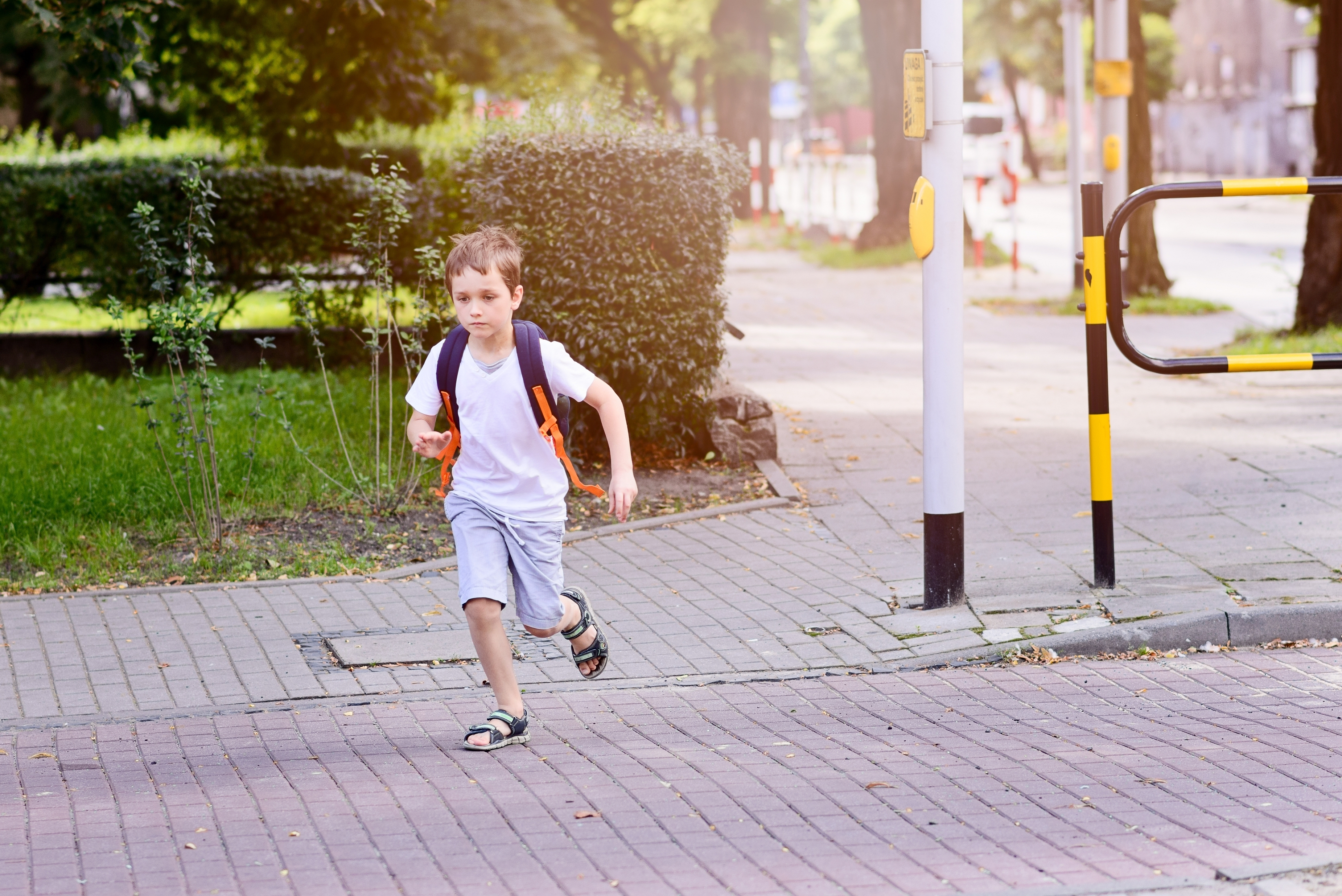 Little 7 years schoolboy is running on street | Source: Shutterstock.com