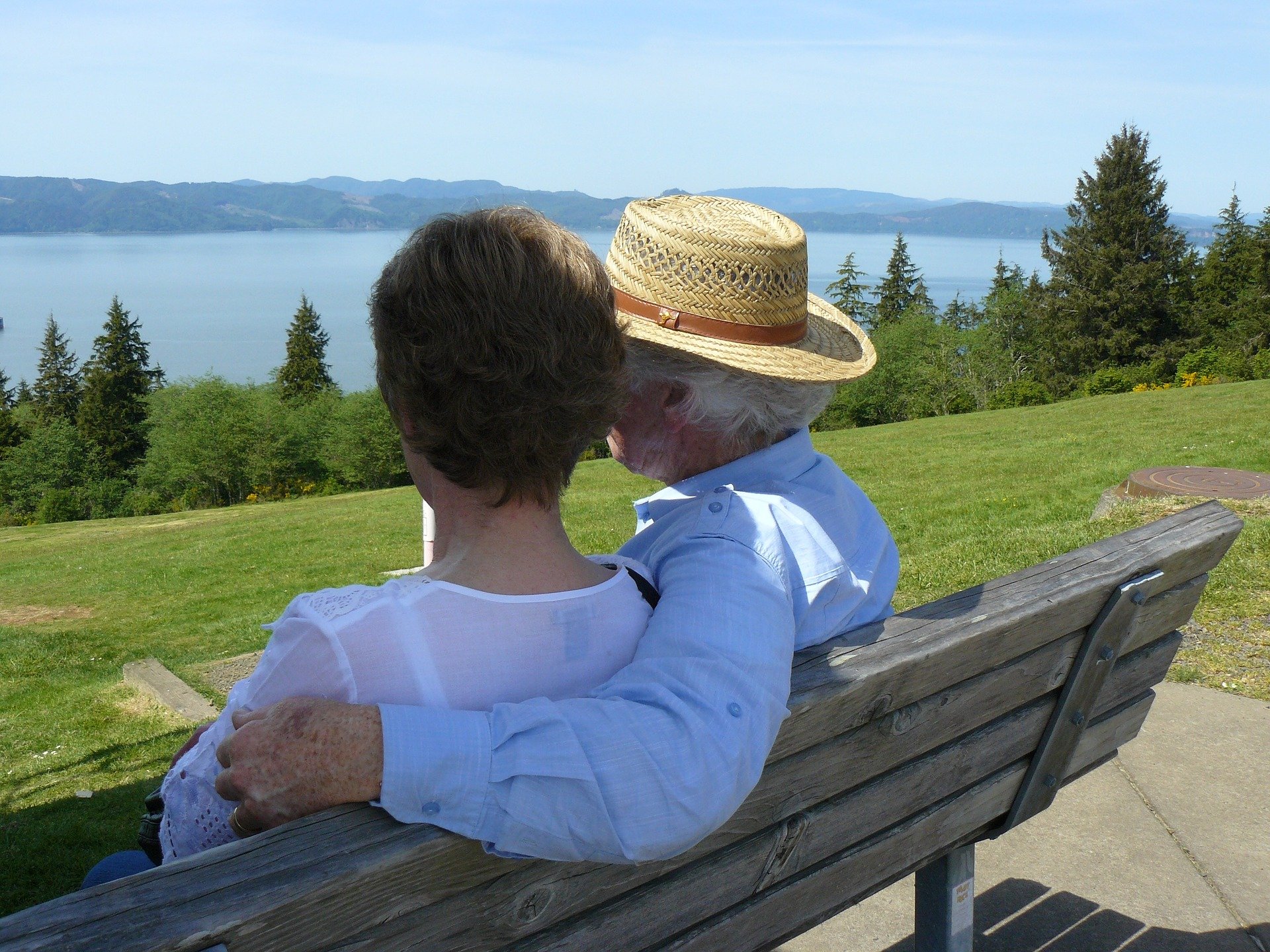 An elderly couple sitting and waiting on a bench. | Source: Pixabay. 