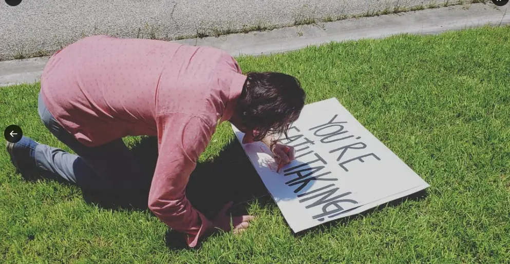 Keanu Reeves writing on the family's sign. | Source: X/@shunt305