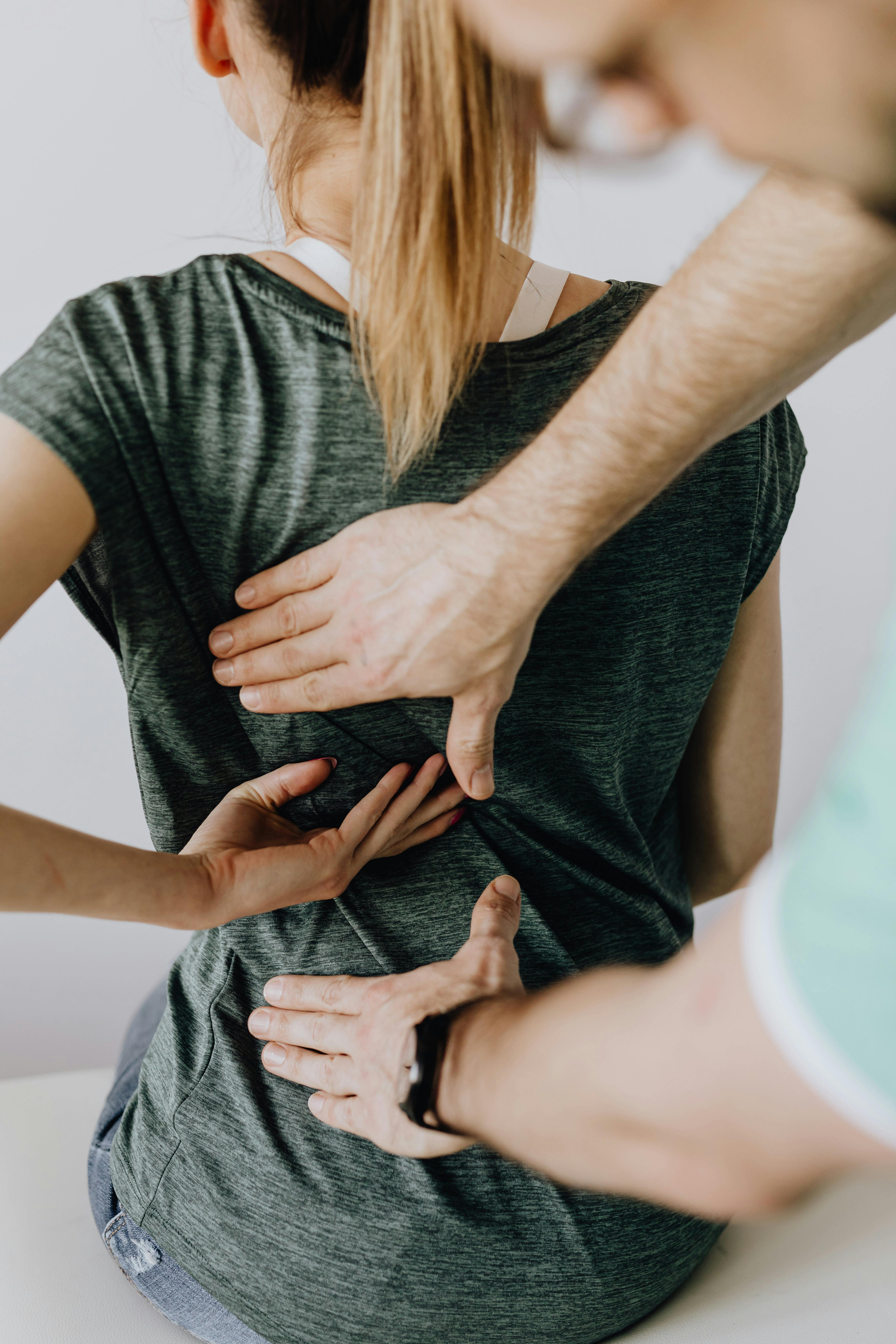 A man tending to a woman's back pain | Source: Pexels