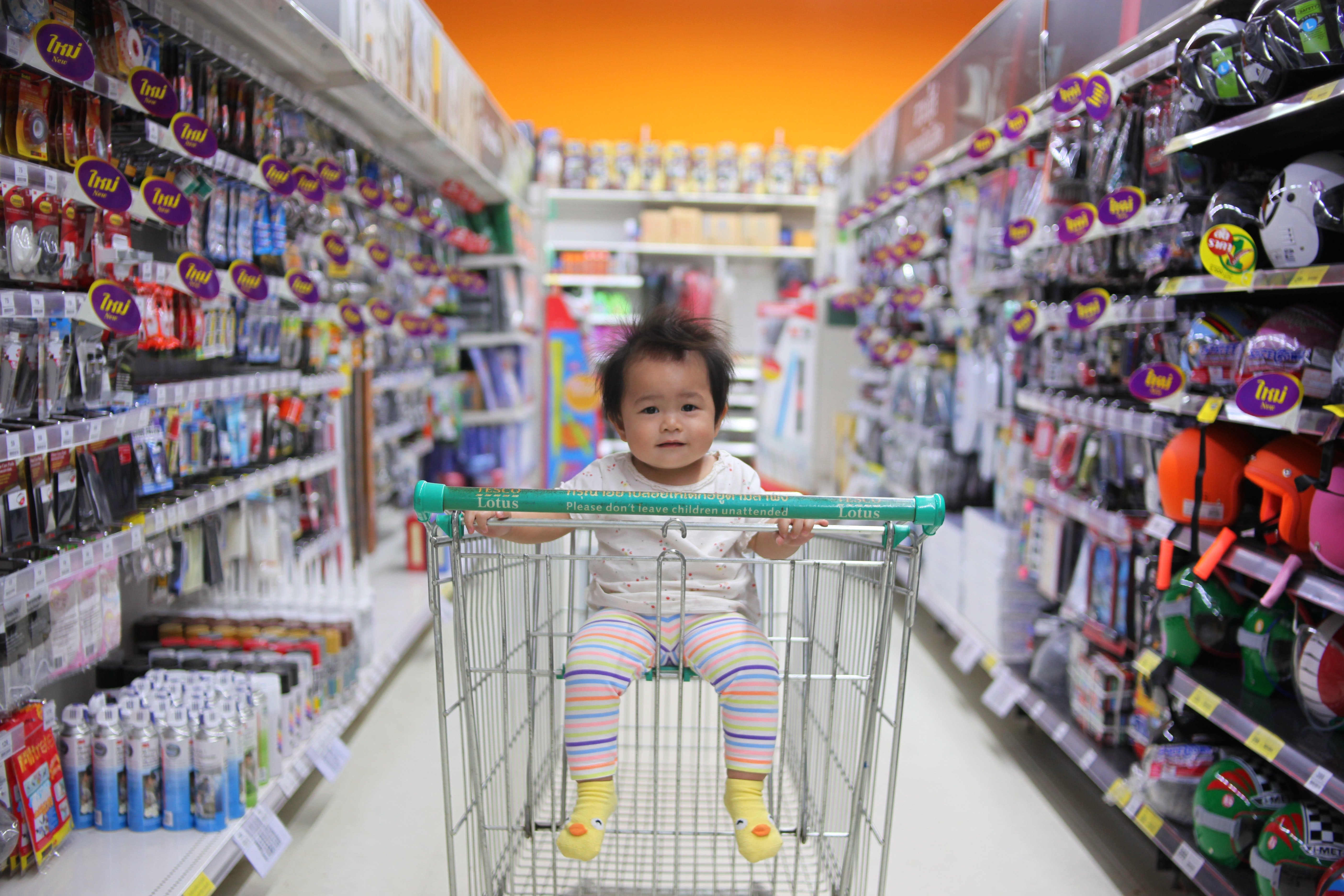 Una bebé sentada en un carrito de supermercado. | Foto: Unsplash