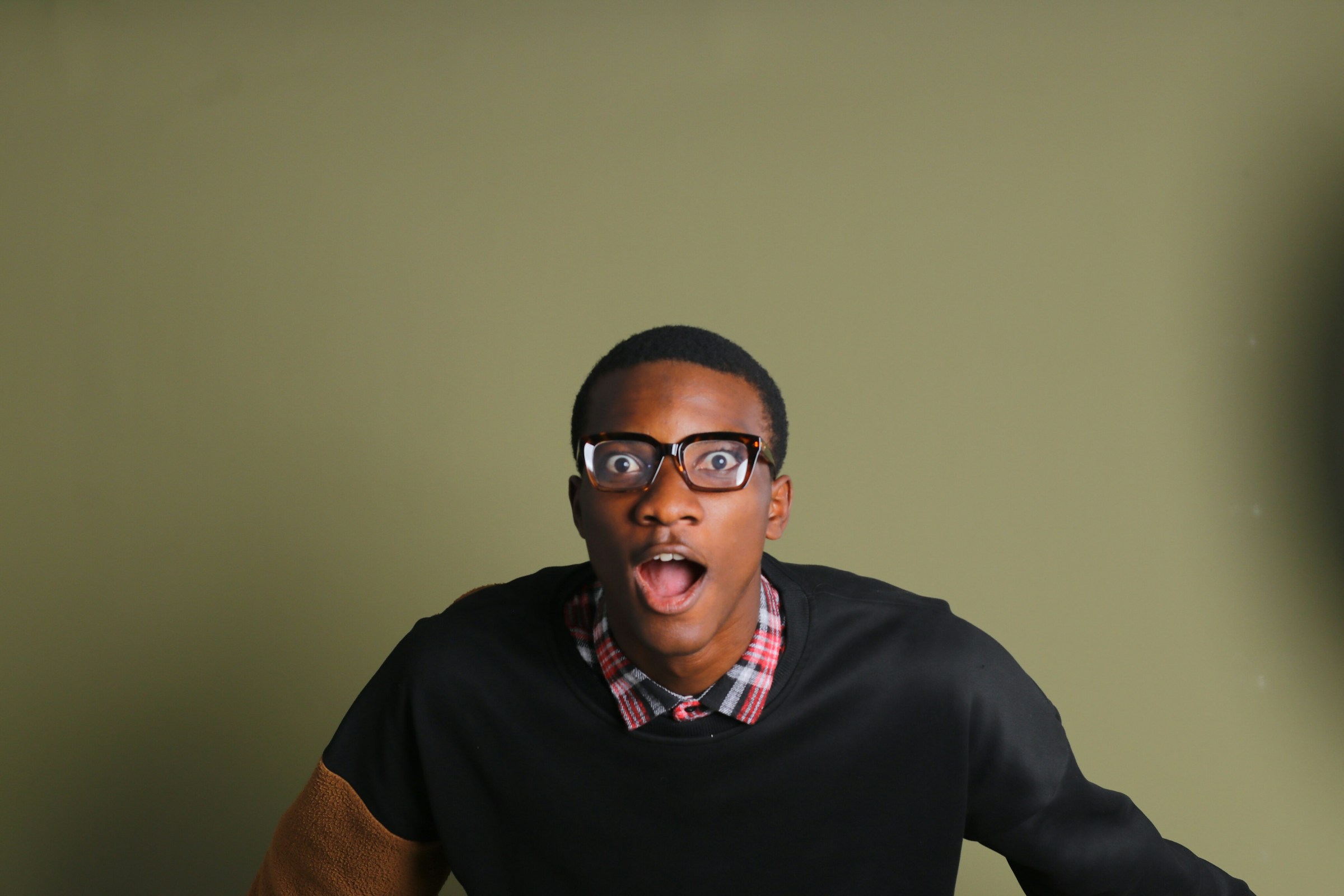 A black man in eyeglasses looking surprised | Source: Unsplash