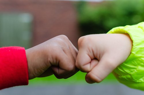 Dos niños se saludan con las manos. | Foto: Shutterstock