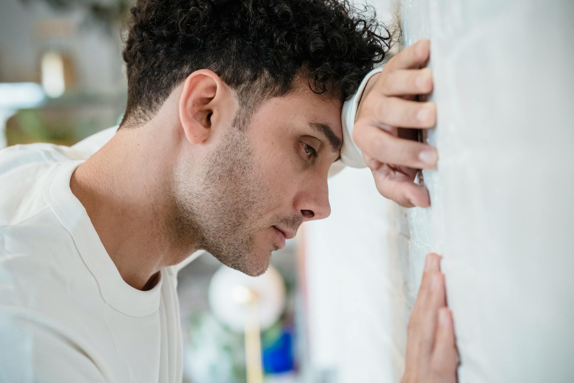 A sad man leaning on the wall | Source: Pexels