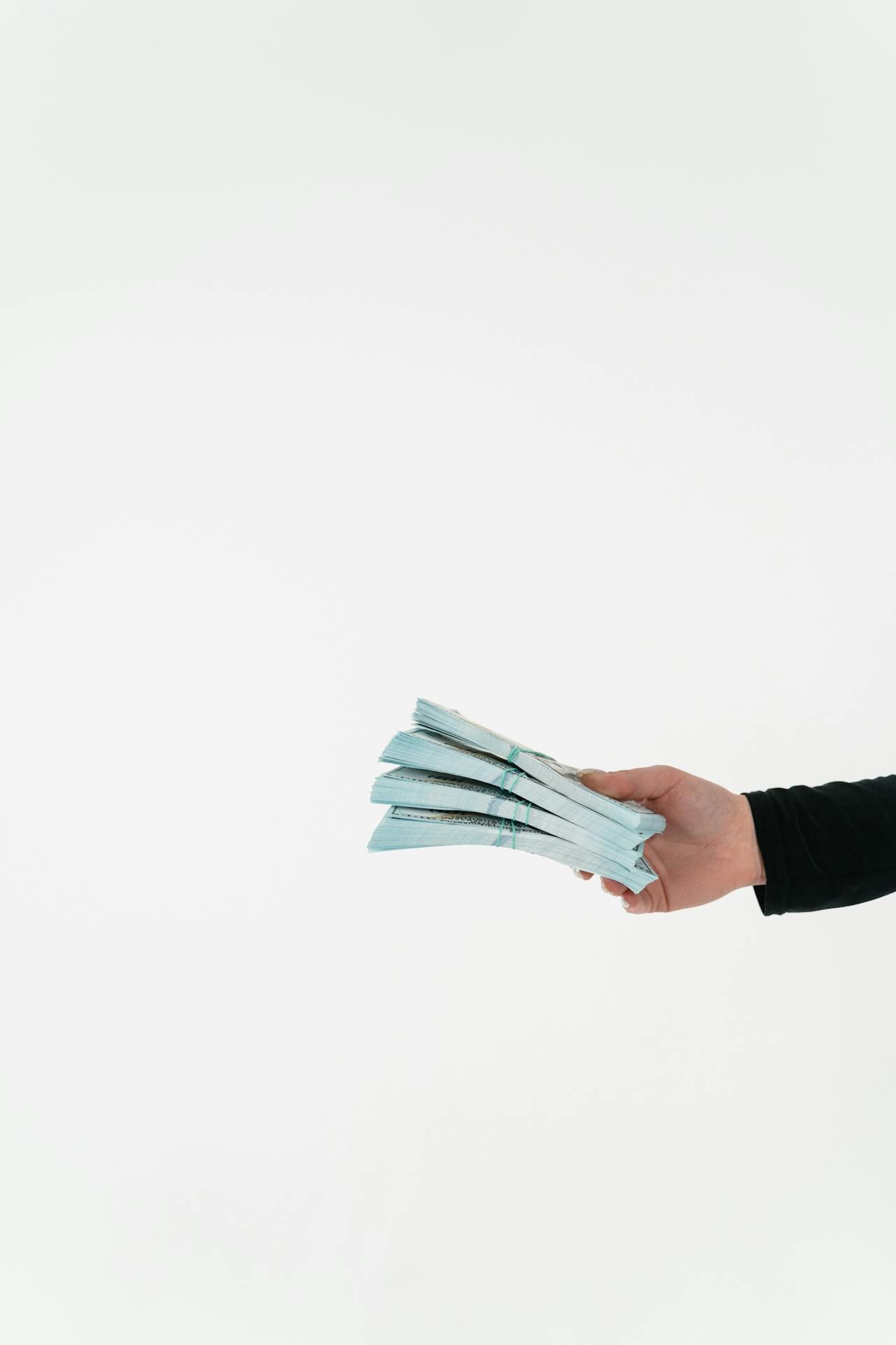 A woman holding bundles of money | Source: Pexels
