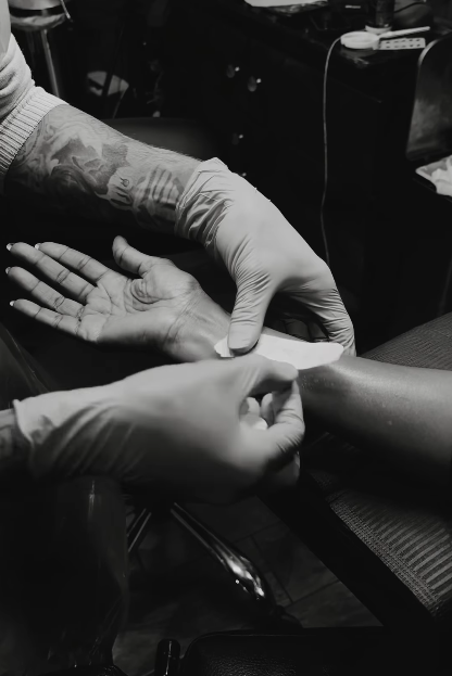 A tattoo artist placing a stencil on Iman's inner forearm, from a video dated January 10, 2026 | Source: Instagram/the_real_iman