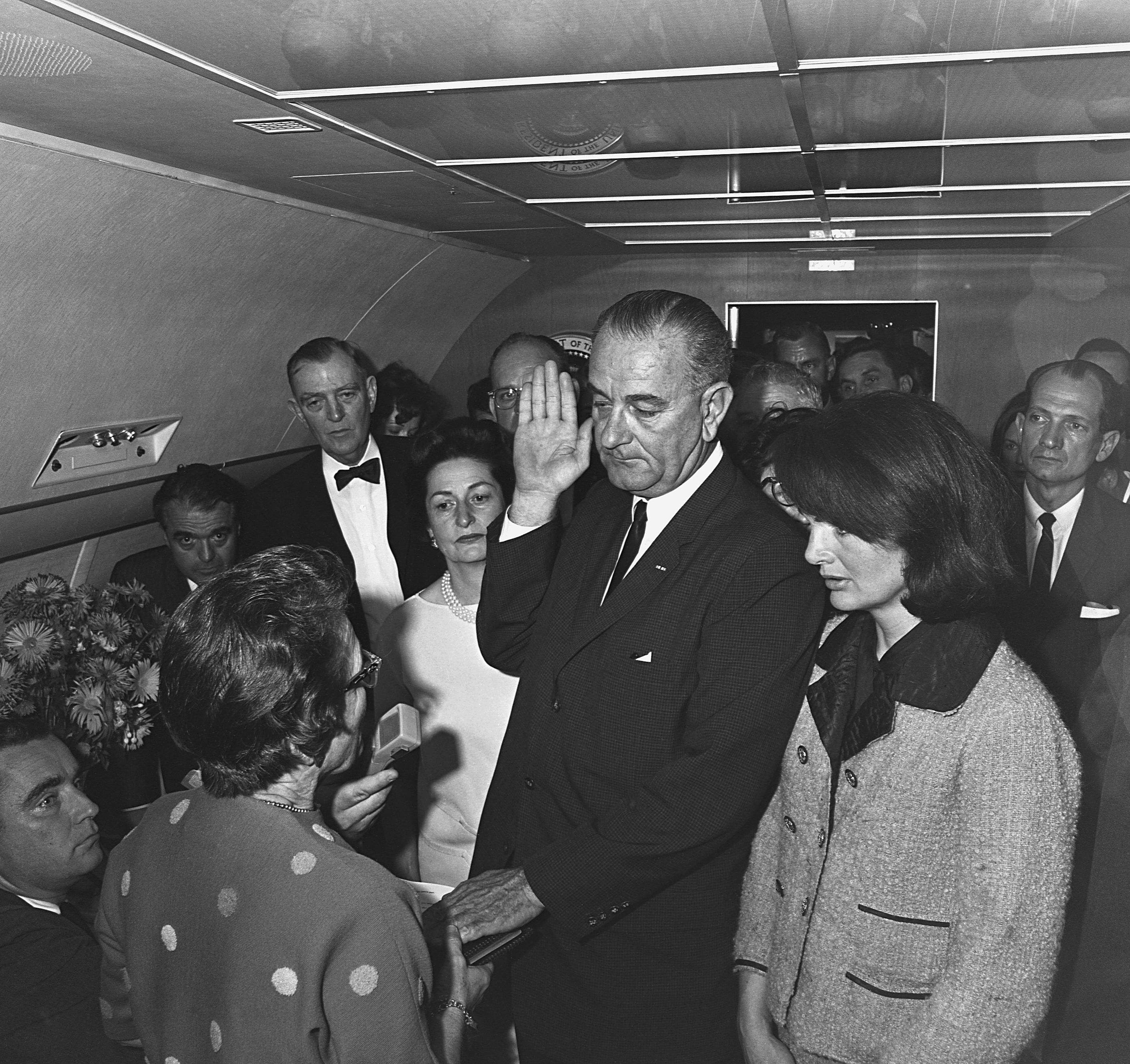 President Lyndon B. Johnson takes the oath of office aboard Air Force One after the assassination of John F. Kennedy. Kennedy's wife Jacqueline and Johnson's wife, Lady Bird, are by his side. November 22, 1963. | Source: Getty Images