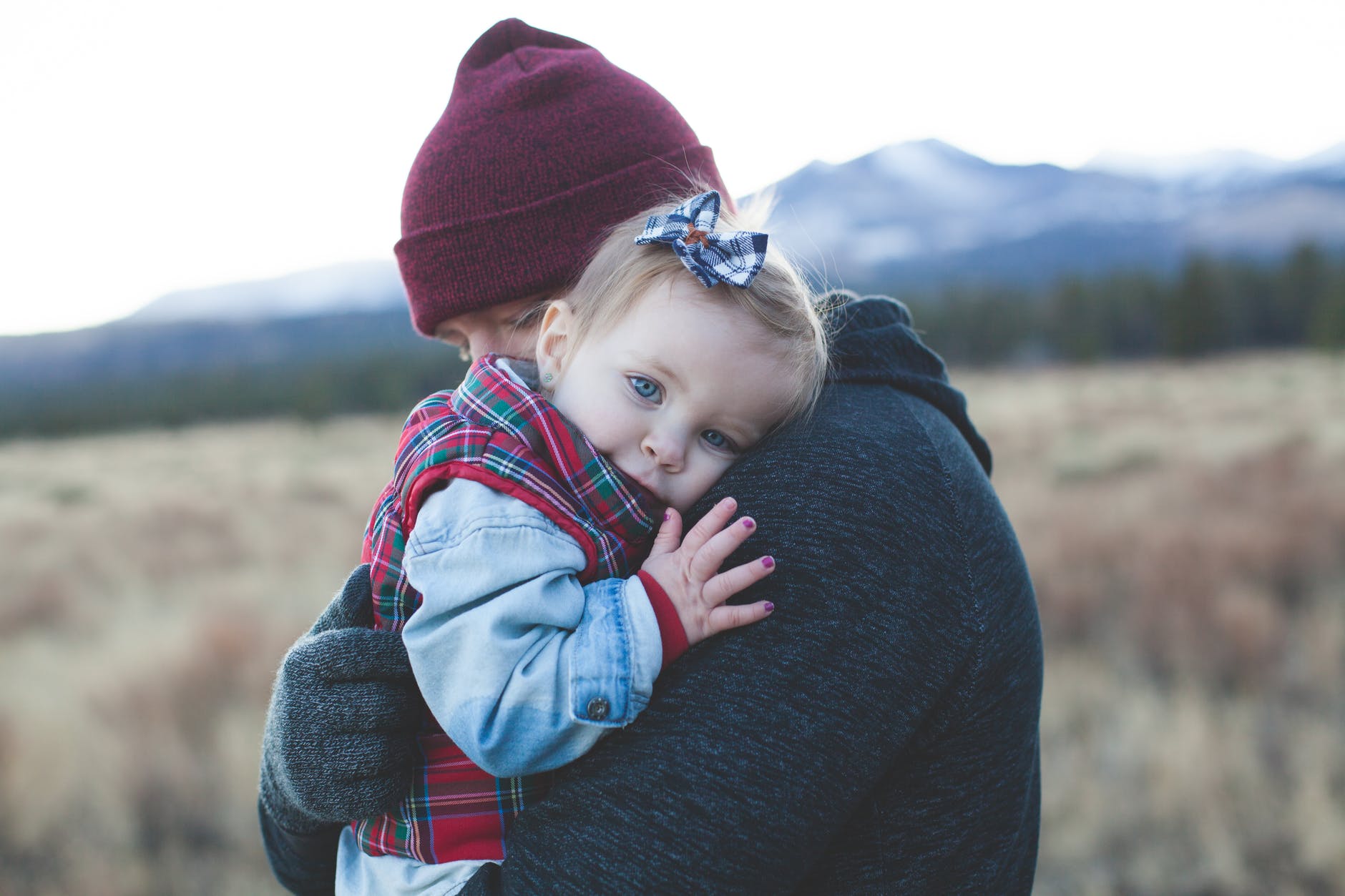 Un bebé en brazos de un adulto cariñoso. | Foto: Pexels.