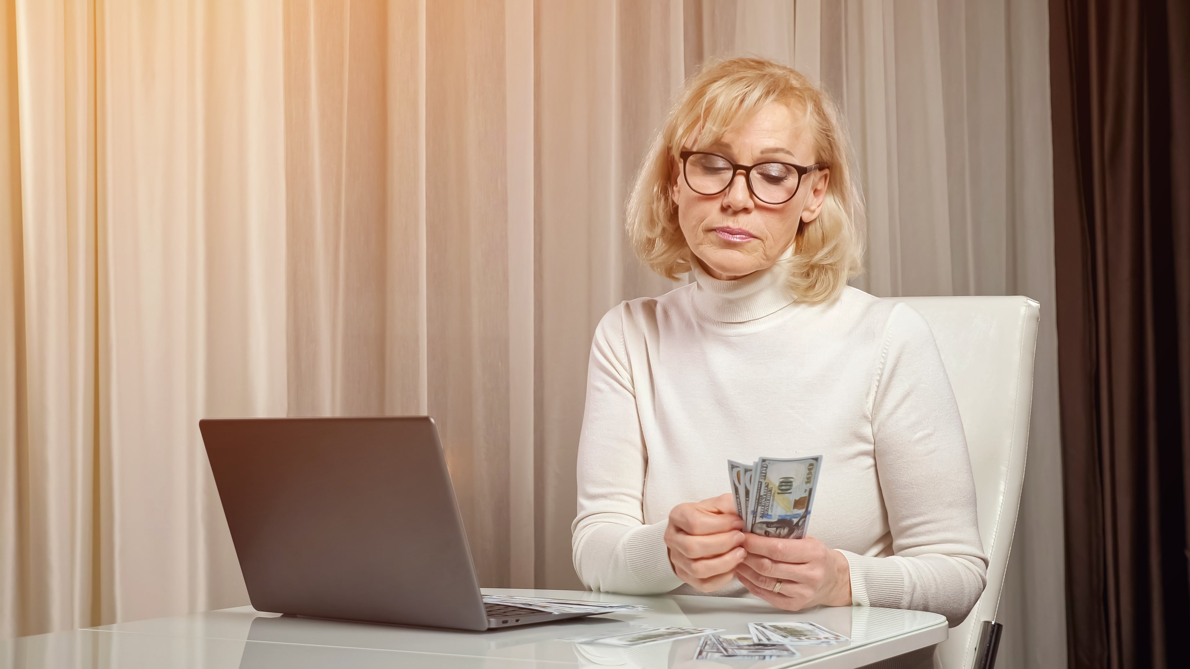 An older woman counting money | Source: Shutterstock