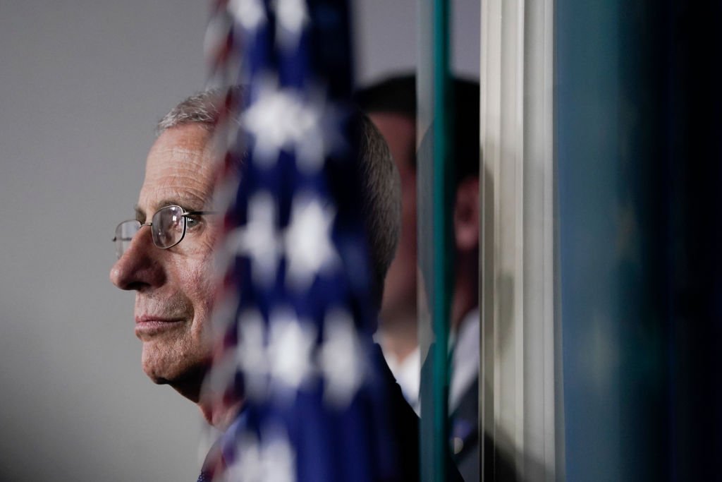 National Institute of Allergy and Infectious Diseases Director Anthony Fauci listens as U.S. President Donald Trump speaks during a briefing on the coronavirus pandemic, in the press briefing room of the White House on March 26, 2020 | Photo: Getty Images