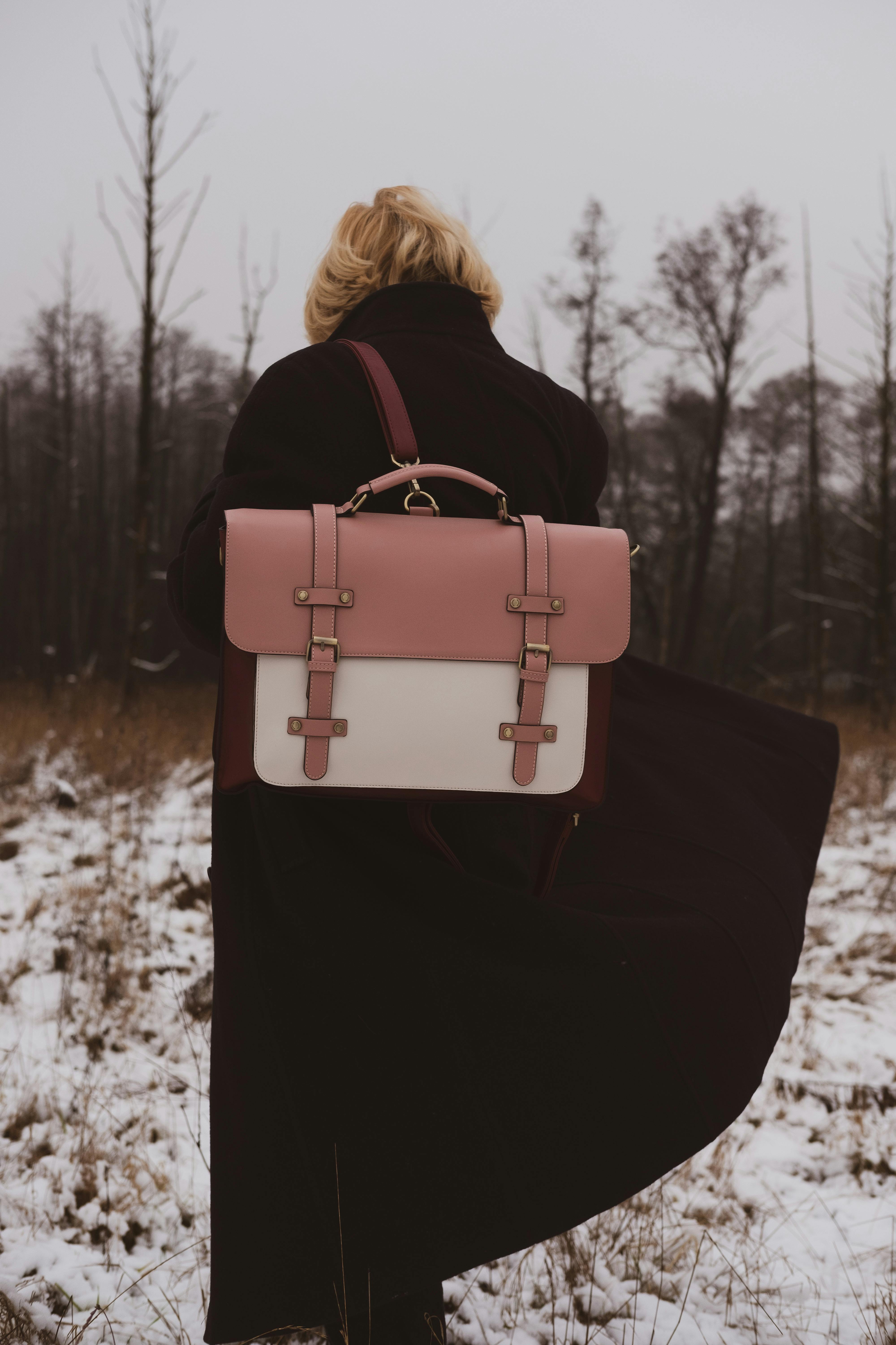 A woman carrying a backpack while standing on snow | Source: Pexels