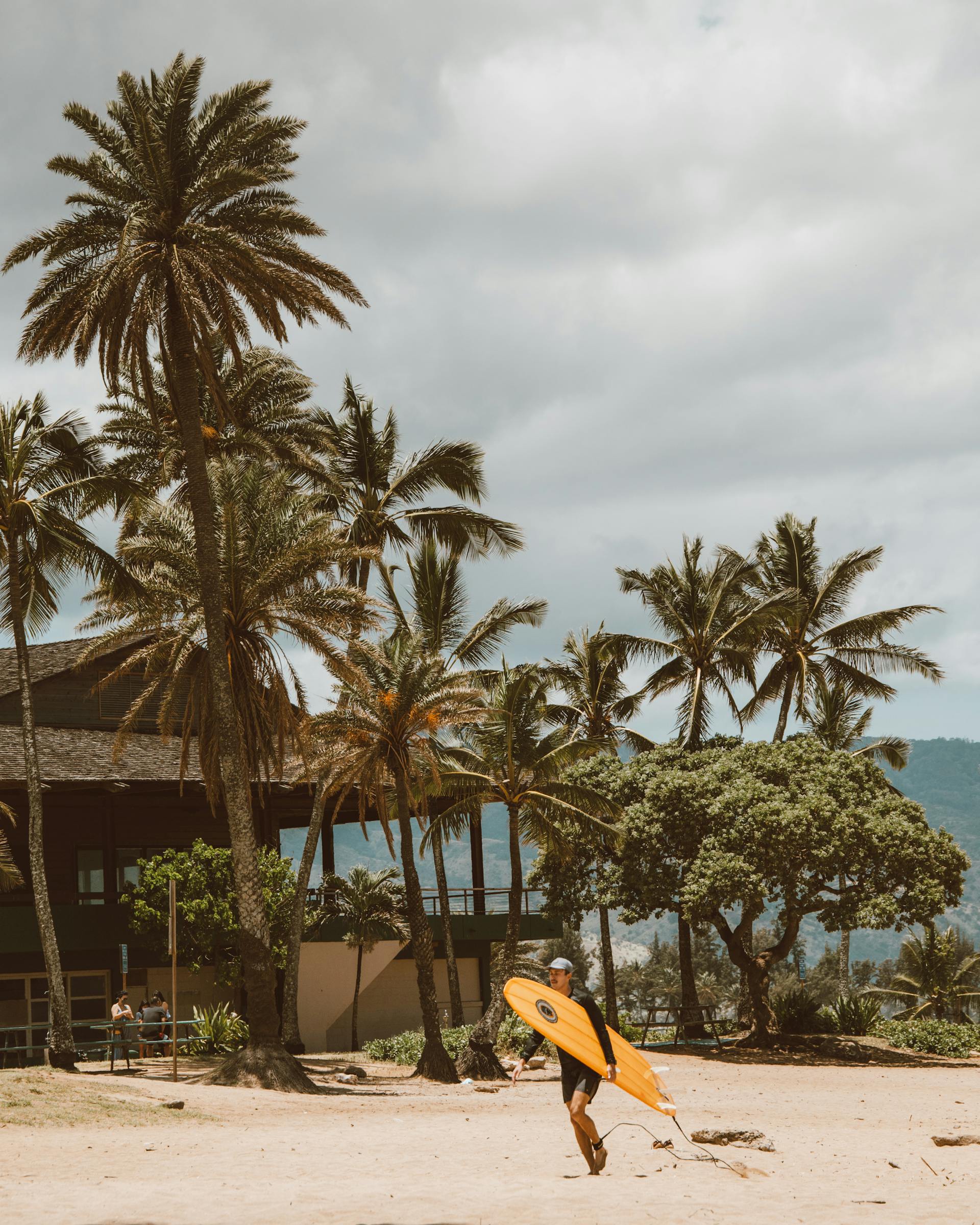 A man walking with a surfboard on a beach | Source: Pexels