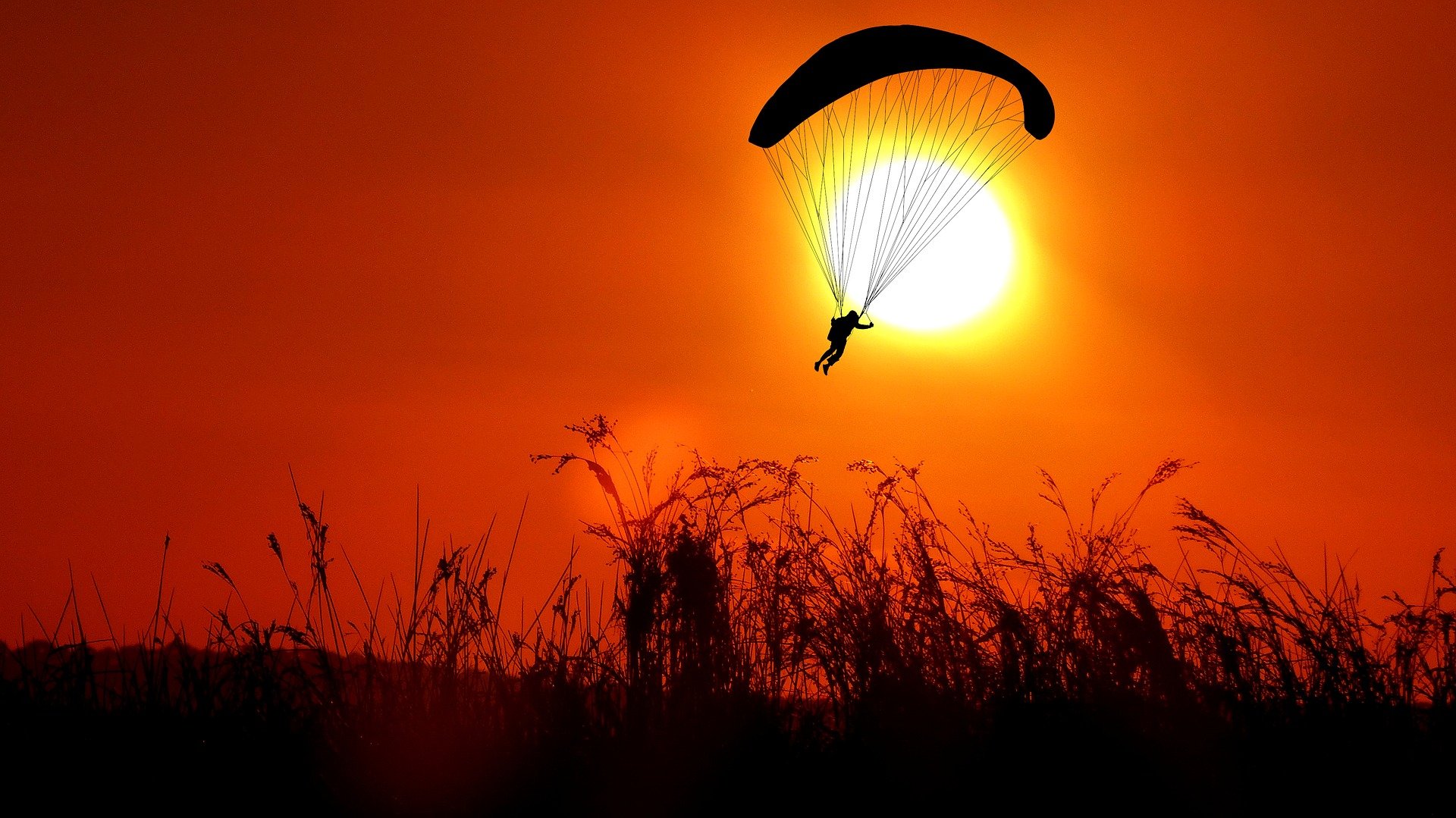 Un parachutiste pendant le coucher du soleil. | Photo : Pixabay/RENE RAUSCHENBERGER