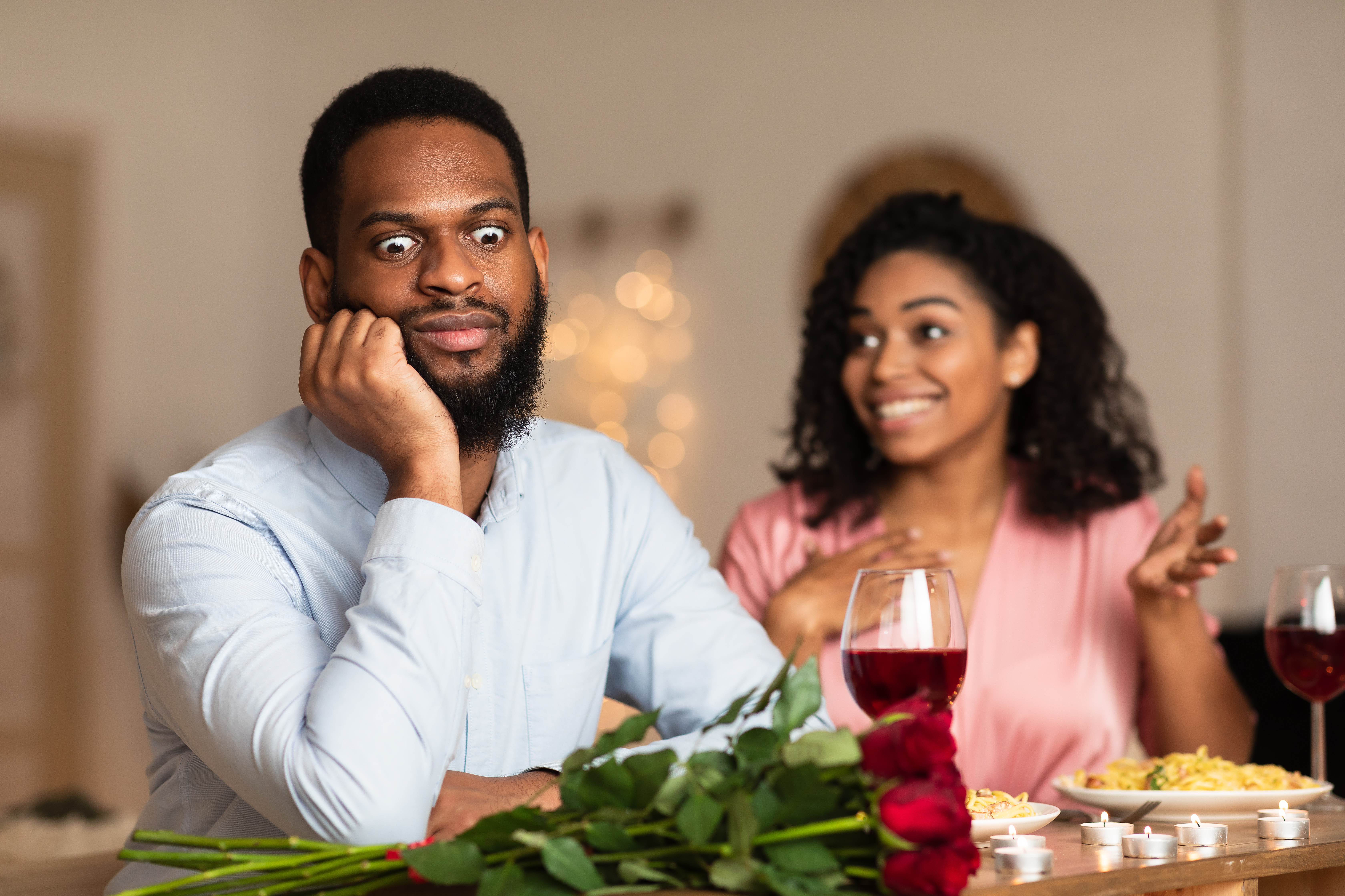 Dissatisfied shocked black man listening to an excited and emotional woman talking | Source: Shutterstock