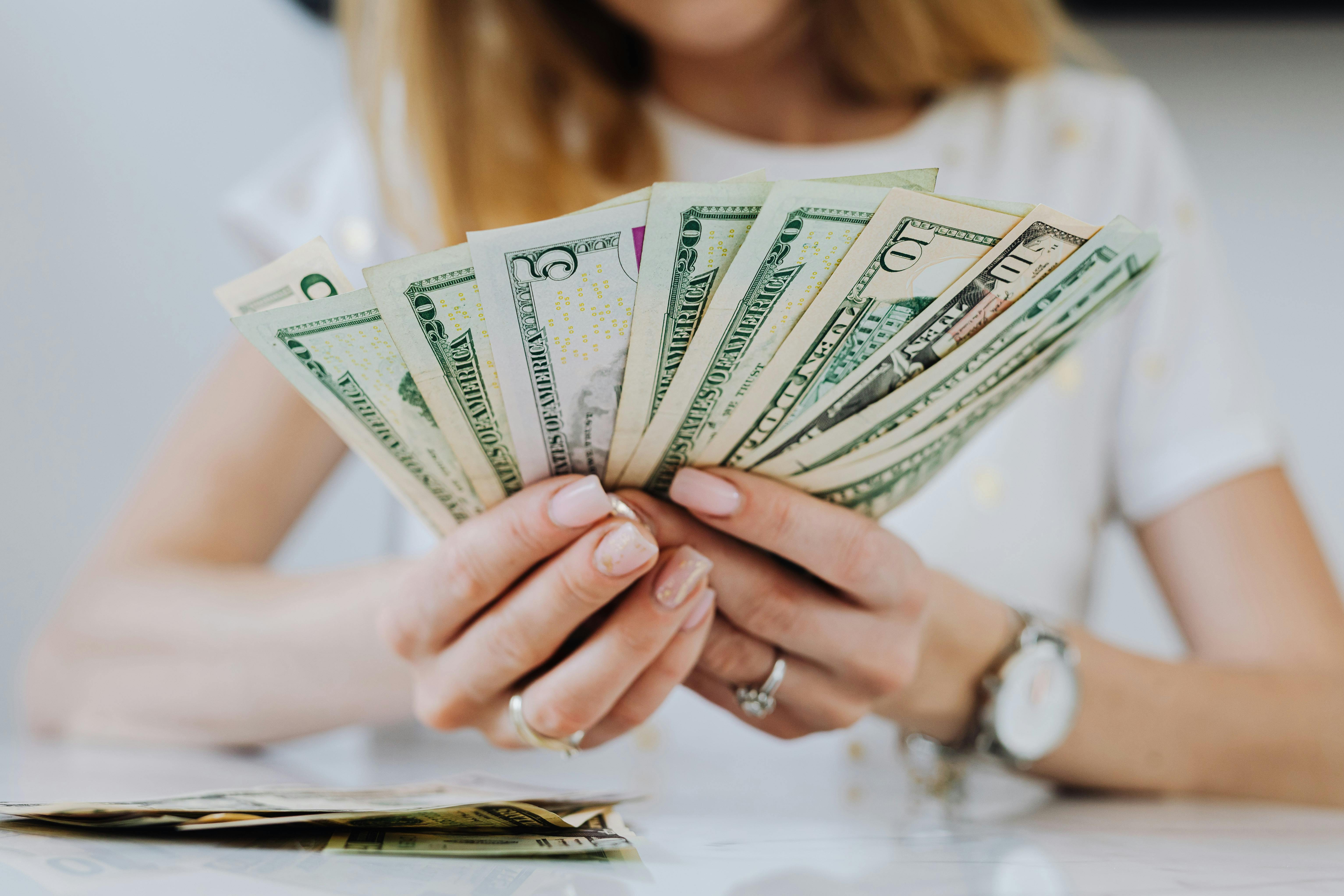 A woman holding dollar bills | Source: Pexels