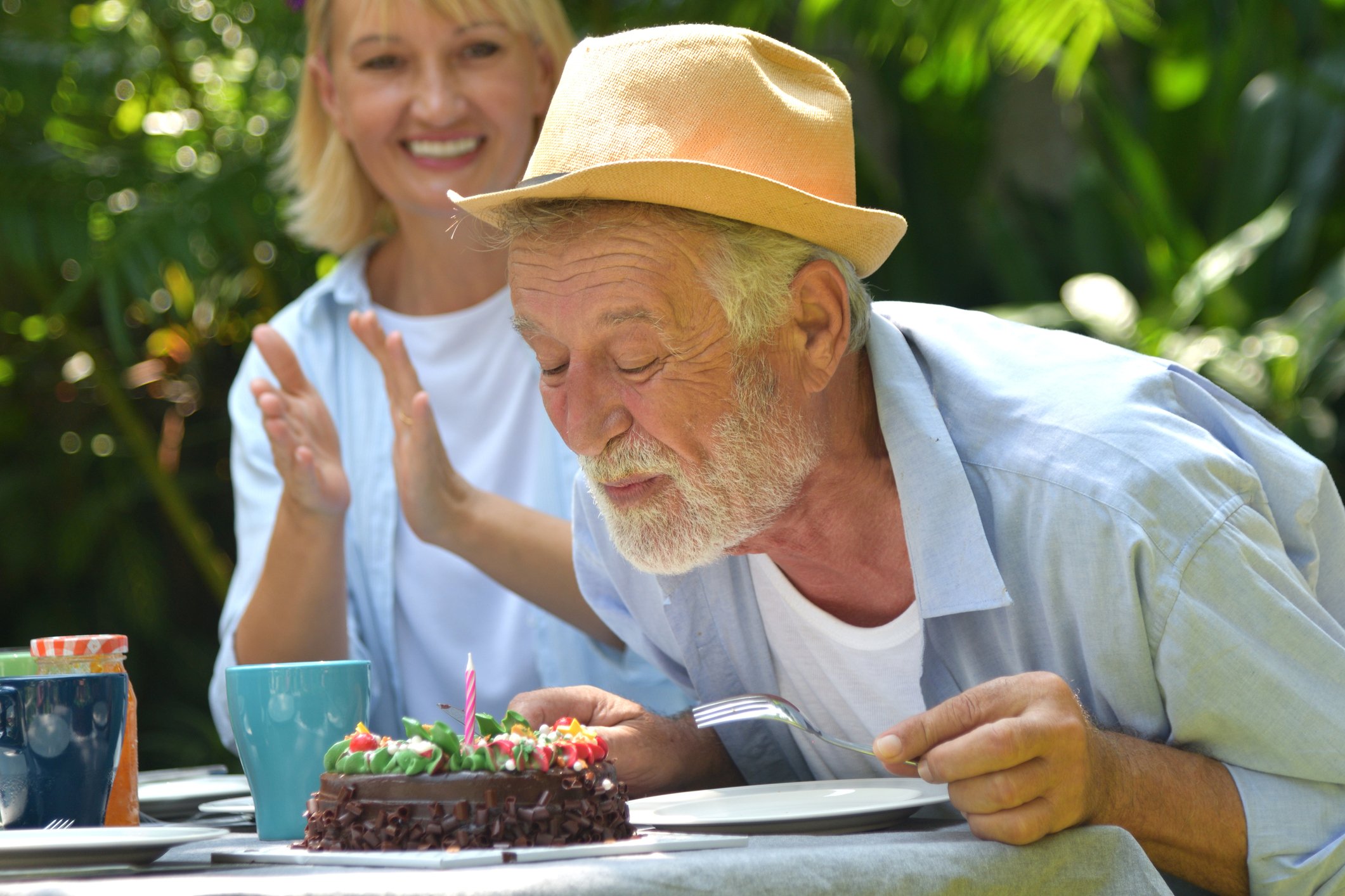 Anciano soplando velas de su paste cumpleaños en la fiesta familiar.| Foto: Getty Images