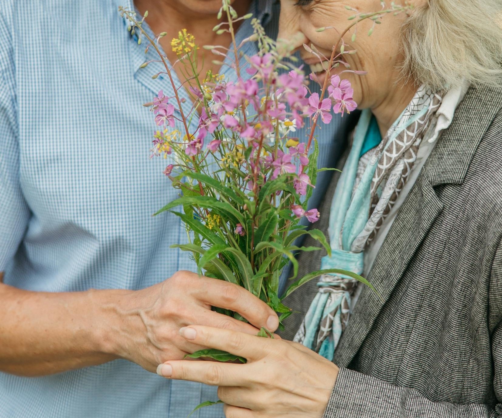 Close-up of a happy senior couple holding flowers | Source: Pexels