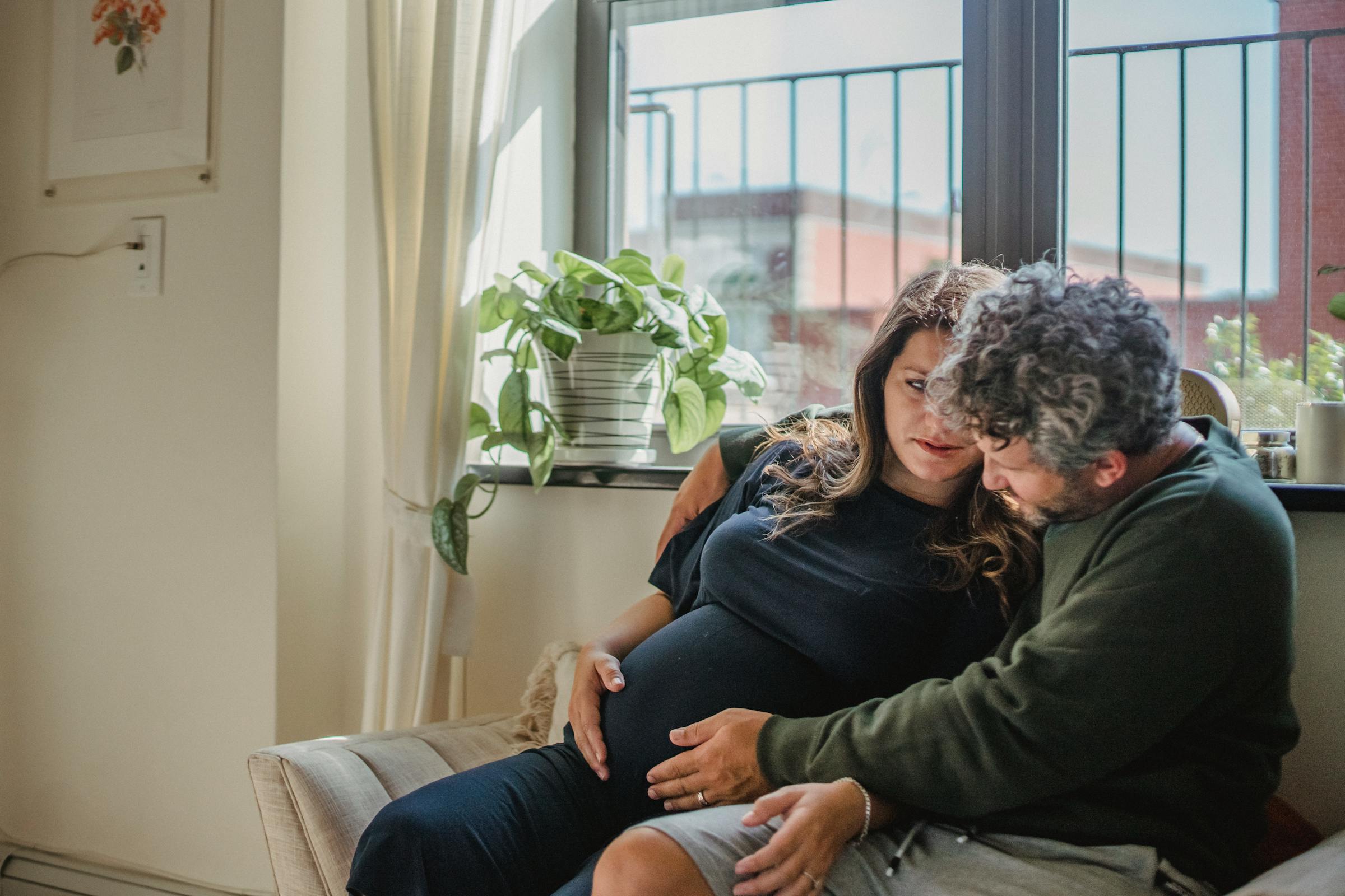 A pregnant couple sitting together | Source: Pexels
