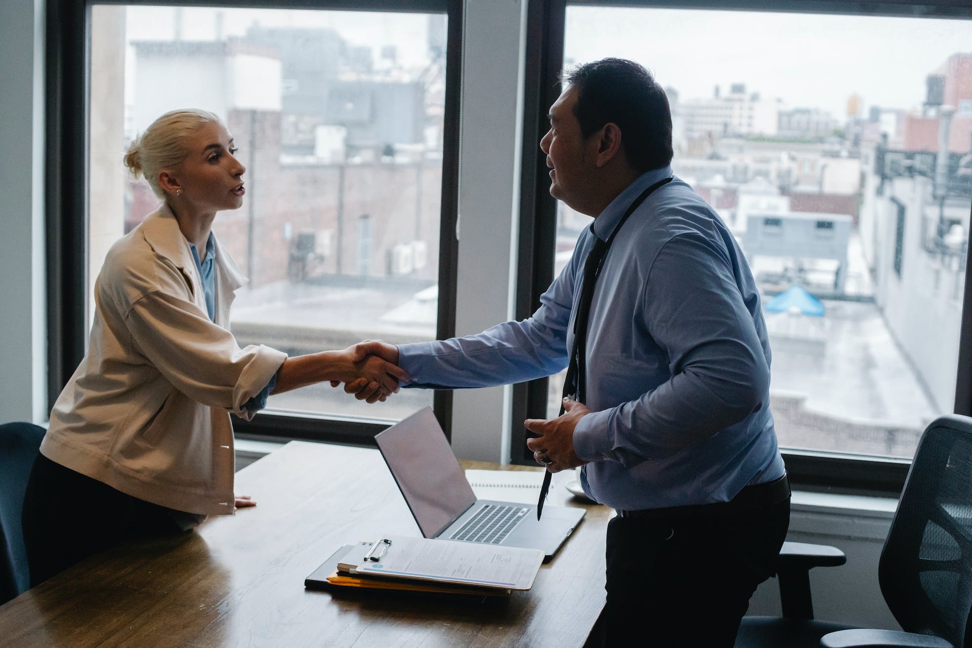 A woman shaking hands with a man in an office | Source: Pexels
