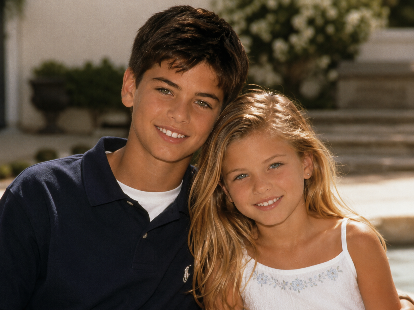 In an AI-generated portrait, Fabio and Larissa Meek’s imagined son and daughter lean together with warm smiles, wearing a navy polo and white sundress in a polished family photo style. | Source: ChatGPT