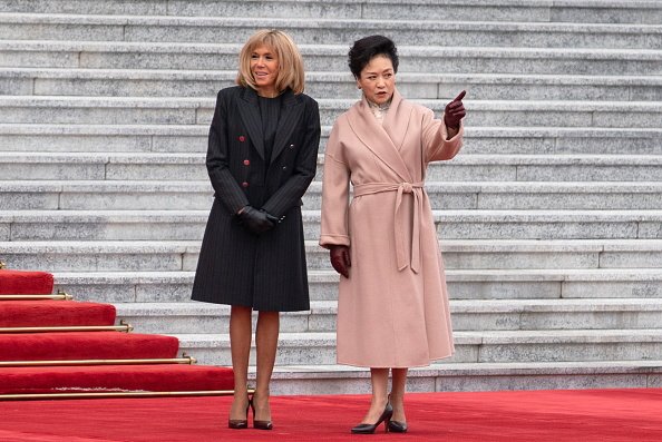 Brigitte Macron et la Première Dame de Chine, Peng Liyuan, lors d'une cérémonie d'accueil. | Photo : Getty Images