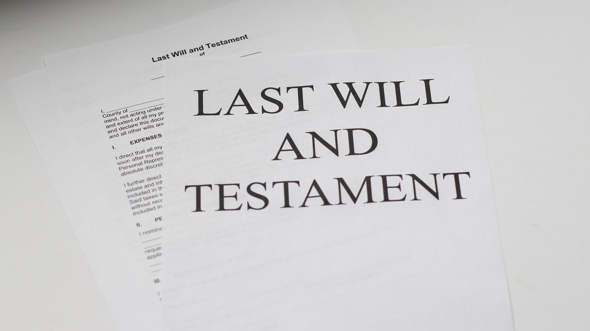 Unas hojas de papel con las palabras "última voluntad" y "testamento" escritas. | Foto: Unsplash