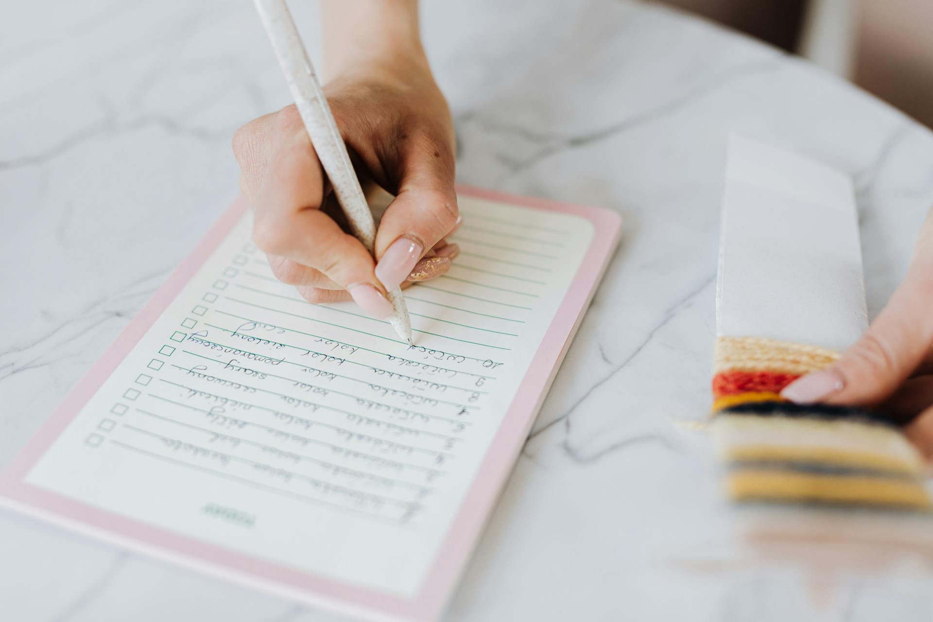 A woman writing in a notepad | Source: Pexels