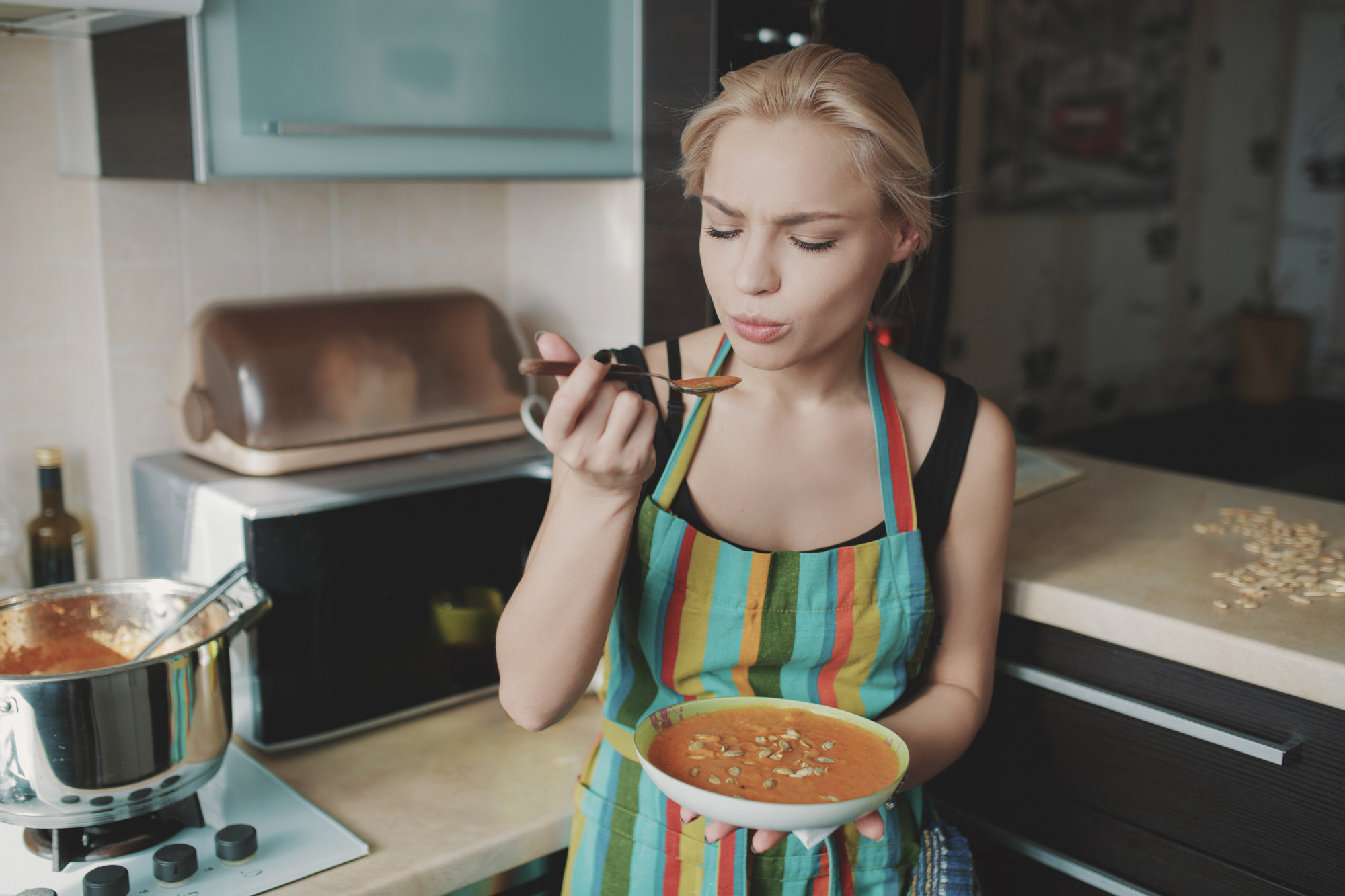 A woman about to taste a dish she prepared | Source: Freepik