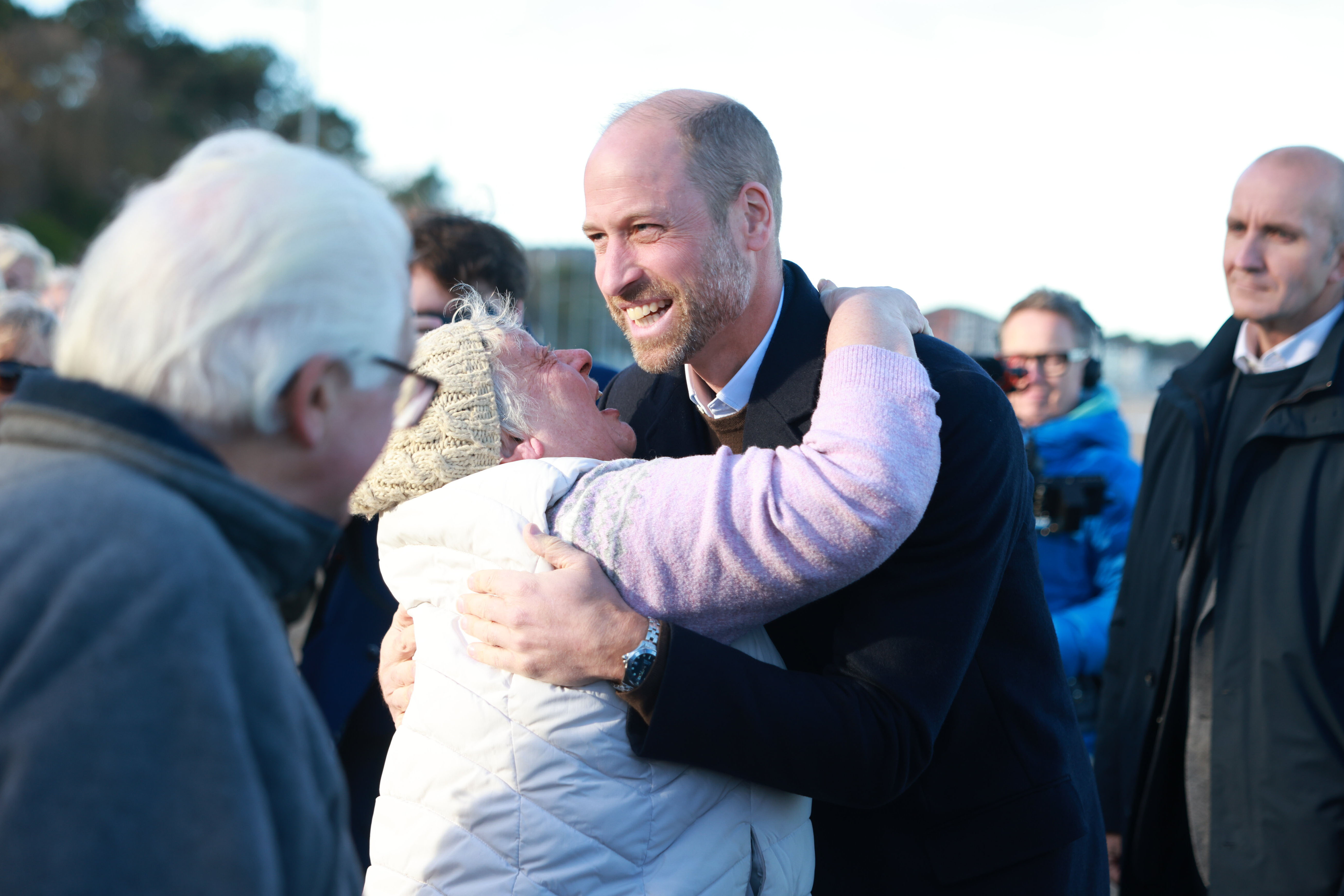 Prince William, Prince of Wales hugs a lady at the beach as he meets young people who are part of the Marine Conservation Society's Youth Ocean Network on 25 November 2025 in Colwyn Bay, Wales. | Source: Getty Images