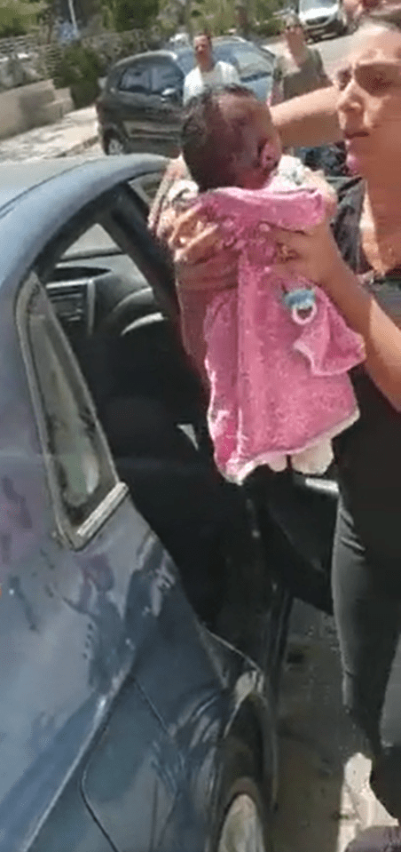 Woman lifting a baby out of a car. │Source: Reddit/u/hardisc